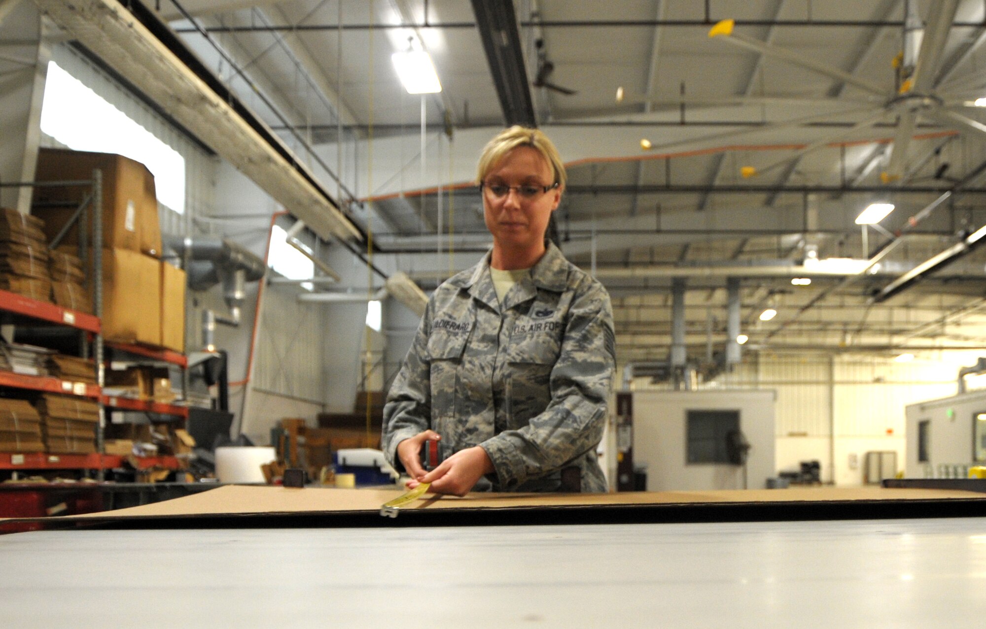 Tech. Sgt. Alison Caldieraro, NCO in charge of outbound freight section of Traffic Management Office, uses a machine to make boxes to ship material in at Scott Air Force Base, Ill. Jan. 7. She was recently step-promoted by the 375th Air Mobility Wing commander under the Stripes for Exceptional Performers program. (U.S. Air Force photo/ Staff Sgt. Stephenie Wade)