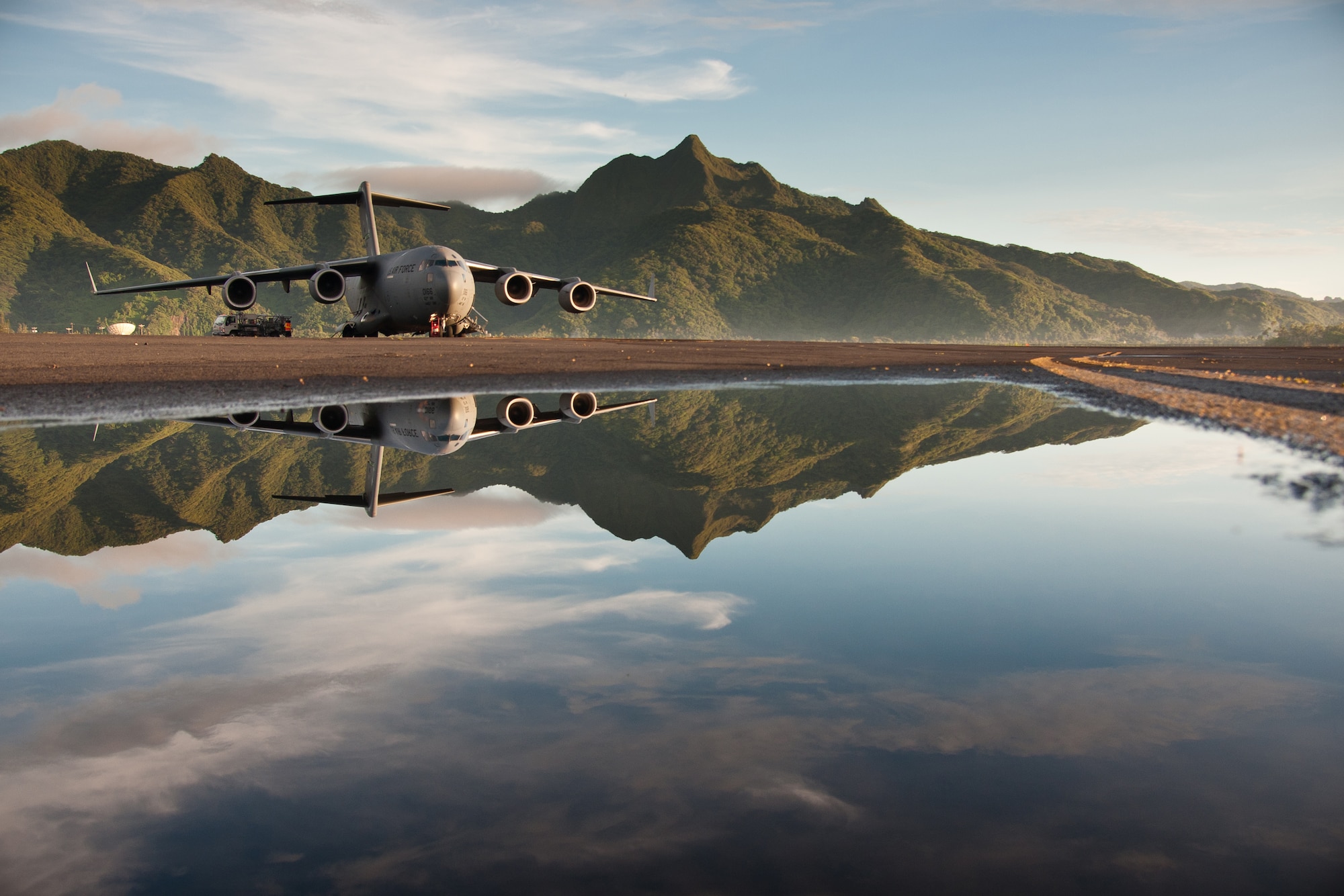 A McChord C-17 Globemaster III with a 446th Airlift Wing aircrew sits on the runway at Pago Pago International Airport in American Samoa Dec. 16, 2012. The crew was enroute to Royal Australian Air Force Base Richmond, Australia, in support of a joint operation. Tropical Cyclone Evan had passed over American Samoa Dec. 12-16 causing 6,000 people to take shelter in evacuation centers and $4.1 million in damages to infrastructure. The puddle in the foreground is a result of the rains from that storm system. (U.S. Air Force Photo/Staff Sgt. Jon Polka)