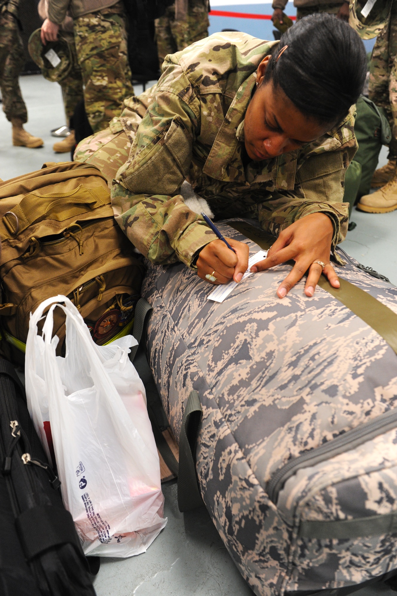 Senior Airman Eboni Philip, a 19th Operations Support Squadron host aviation resource management journeyman, fills out a bag tag for her luggage Jan. 6, 2013, at Little Rock Air Force Base, Ark. Philip has deployed each year for the past four years. (U.S. Air Force photo by Airman 1st Class Ethan Dunagan)
