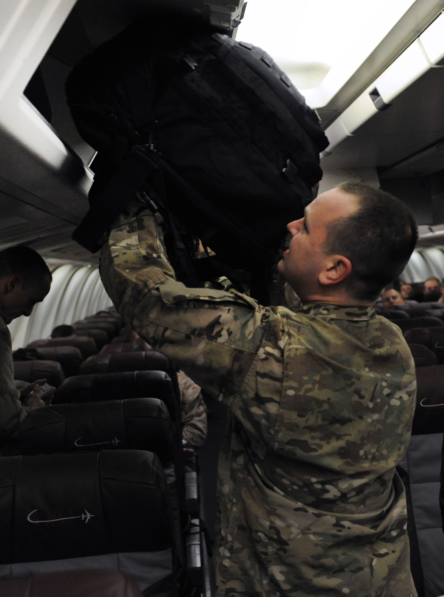 Staff Sgt. Jason Doucette, a 19th Aircraft Maintenance Squadron communications, navigations and mission systems craftsman, stows away his carry-on baggage Jan. 7, 2013, at Little Rock Air Force Base, Ark.  Doucette along with more than one hundred and seventy military members deployed to Southwest Asia to support military operations. (U.S. Air Force photo by Tech. Sgt. Chad Chisholm)