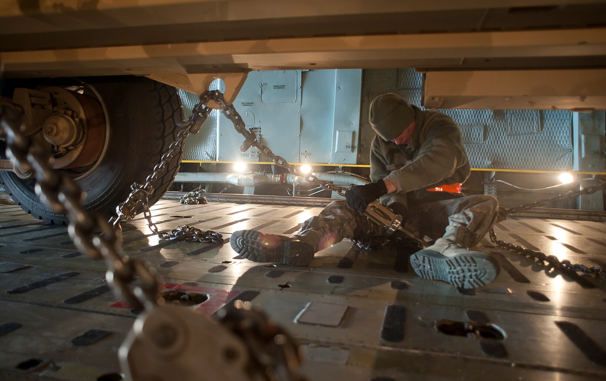 ALTUS AIR FORCE BASE, Okla. – Airman Mikal Moore, Kentucky Air Guard Contingency Response Group aerial porter, chains down an M983 Truck inside a C-5 Galaxy from the 167th Airlift Wing, Martinsburg, W. Va., on the Altus AFB flight line, Jan. 4, 2013. Members of the 97th Air Mobility Wing, Kentucky Air Guard CRG, 31st Air Defense Artillery Army Brigade, Fort Sill, Okla. and 167th Airlift Wing, Martinsburg, W. Va., joined forces to deploy batteries of Patriot-air-defense systems, more than two million pounds of equipment and about 300 personnel from 3-2 Air Defense Artillery Battalion to Turkey in support of the North Atlantic Treaty Organization. (U.S. Air Force photo by Airman 1st Class Levin Boland / Released)