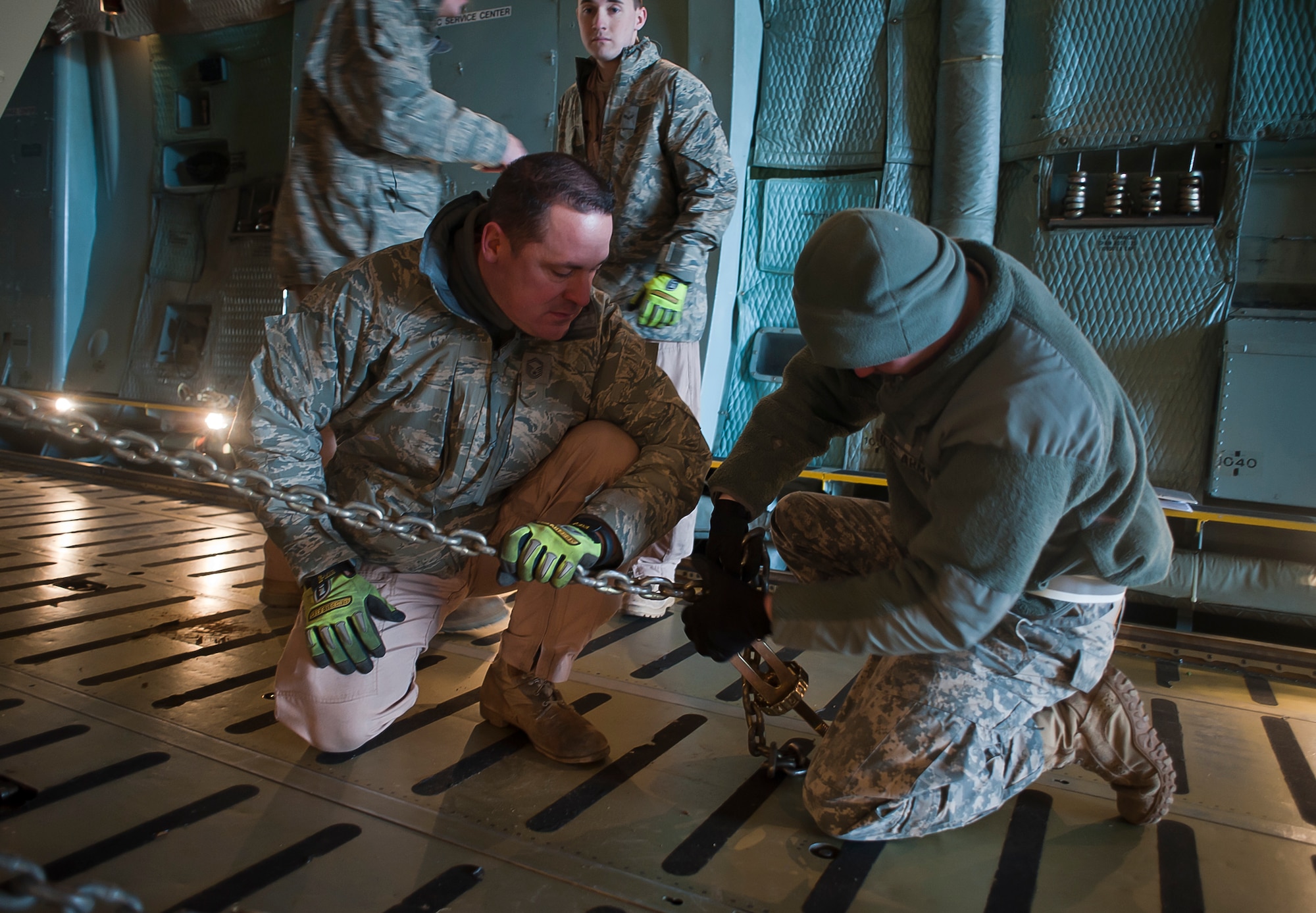 ALTUS AIR FORCE BASE, Okla. – Senior Master Sgt. Mark Snyder, 167th Airlift Wing, Martinsburg, W. Va. loadmaster assists Sgt. Daniel Hanke, Fort Sill Unit Movement Office augmentee, chain down an M983 Truck inside a 167th AW C-5 Galaxy on the Altus AFB flight line, Jan. 4, 2013. Members of the 97th Air Mobility Wing, Kentucky Air Guard Contingency Response Group, 31st Air Defense Artillery Army Brigade, Fort Sill, Okla. and 167th AW, joined forces to deploy batteries of Patriot-air-defense systems, more than two million pounds of equipment and about 300 personnel from 3-2 Air Defense Artillery Battalion to Turkey in support of the North Atlantic Treaty Organization. (U.S. Air Force photo by Airman 1st Class Levin Boland/ Released)