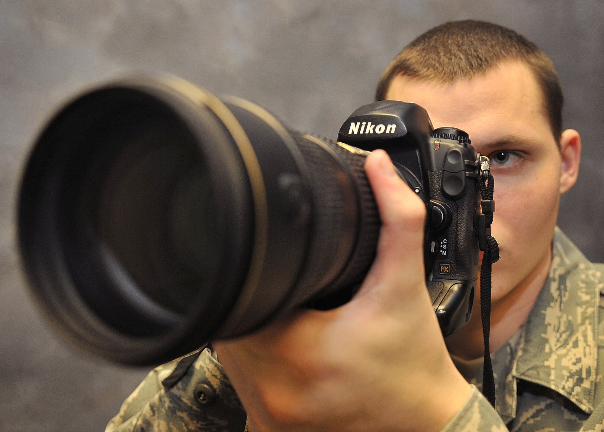 Senior Airman Ethan Morgan, 100th Air Refueling Wing Public Affairs photojournalist, prepares to take a photo Jan. 7, 2013, at RAF Mildenhall, England. (U.S. Air Force photo by Senior Airman Jerilyn Quintanilla/Released)
