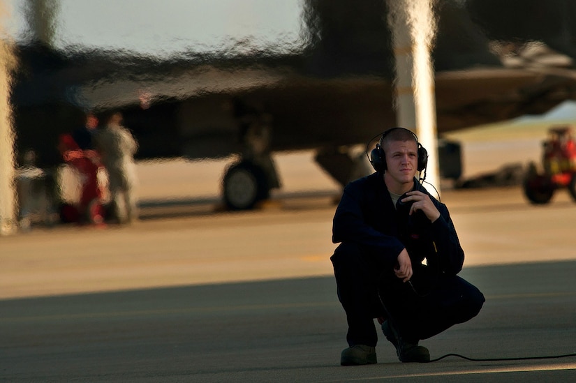 Airman 1st Class Benjamin Speer, an F-22 crew chief, watches over an aircraft and communicates with a pilot during a preflight inspection before a training mission. (U.S. Air Force photo/Tech. Sgt. Bennie J. Davis III)