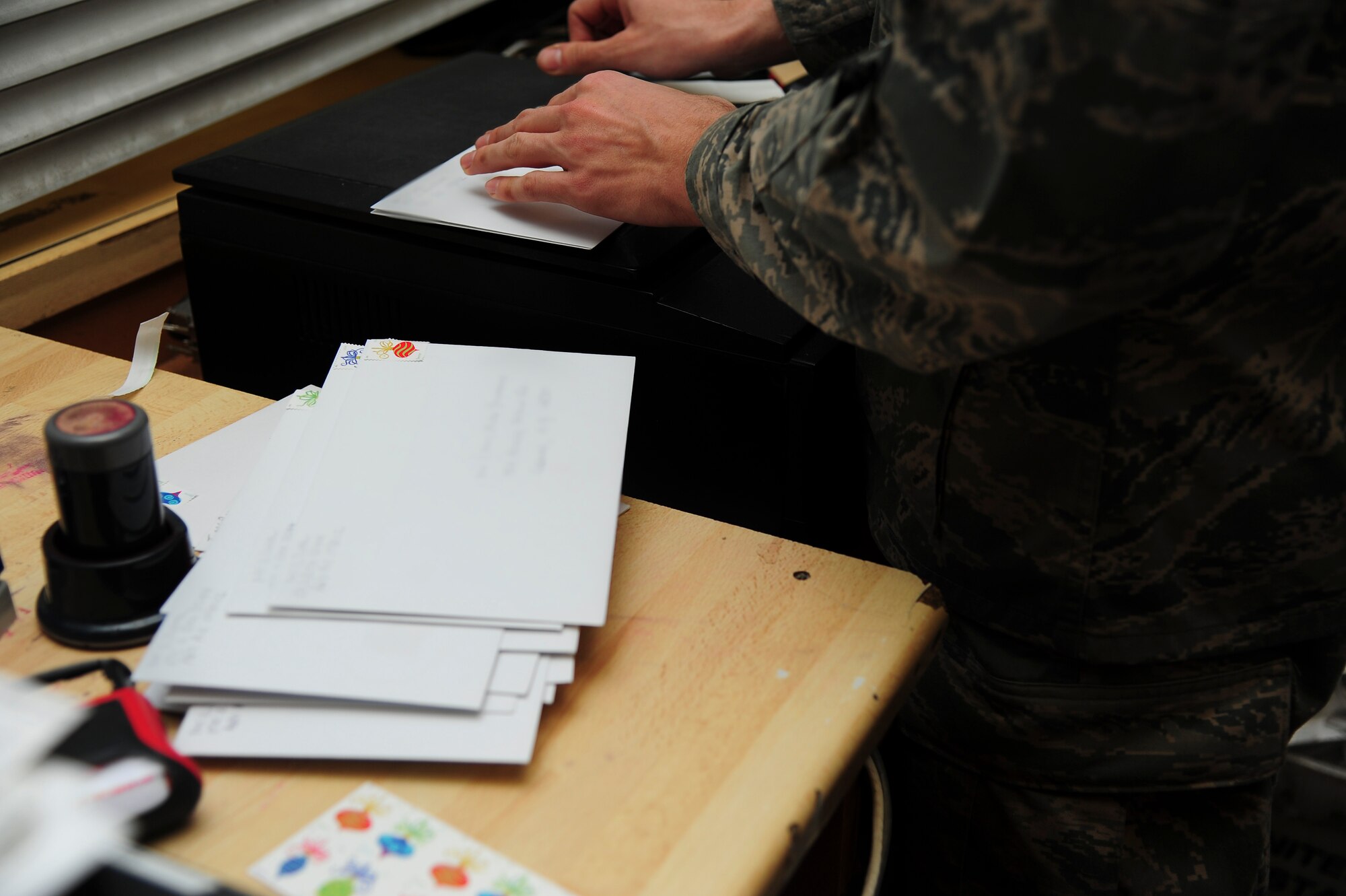 Senior Airman Thayne Rooney, 86 Communication Squadron postal specialist, stamps and sorts letters at the Northside Post Office on Ramstein Air Base, Germany, Dec. 17, 2012. The post office receives its highest customer traffic during the holiday season. (U.S. Air Force photo/Airman 1st Class Jordan Castelan)
