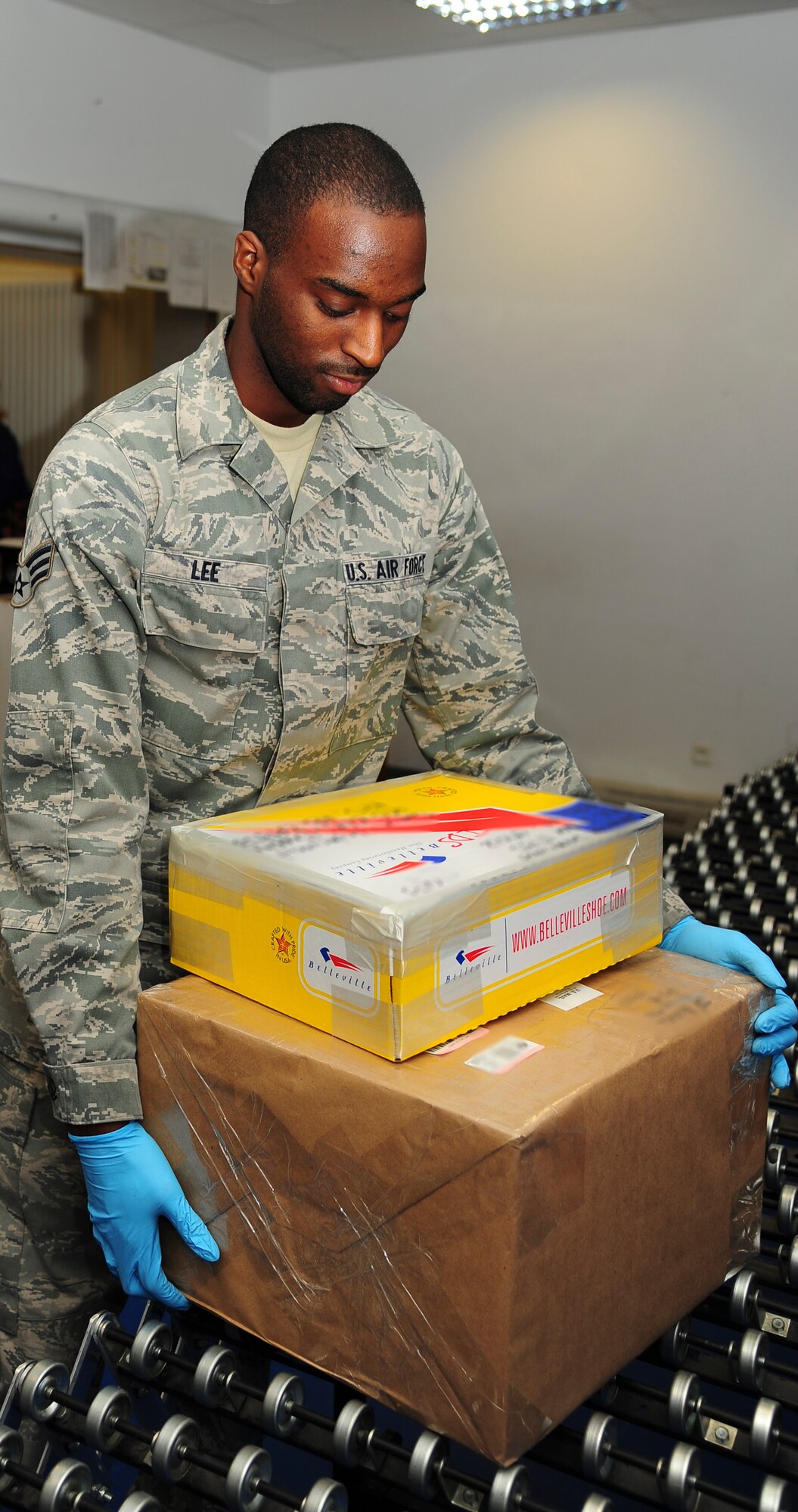 Senior Airman Jonathan Lee, 86th Communication Squadron postal specialist, brings mail to the service window at the Northside Post Office on Ramstein Air Base, Germany, Dec. 17, 2012. The post office receives its highest customer traffic during the holiday season. (U.S. Air Force photo/Airman 1st Class Jordan Castelan)