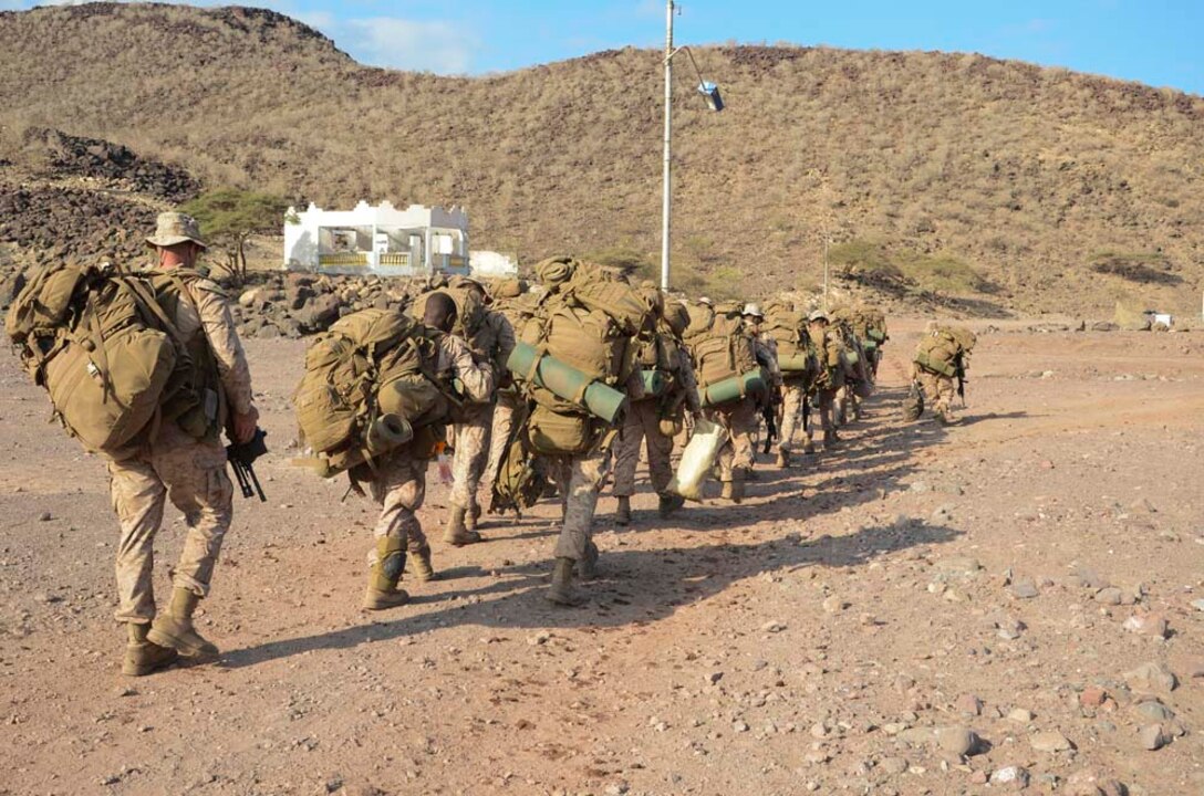 Marines assigned to 1st Platoon, Kilo Company, Battalion Landing Team 3/5, 15th Marine Expeditionary Unit (MEU), trek back to amphibious assault ship USS Peleliu (LHA 5) after completing an exercise at Arta Beach, Djibouti, Dec. 13. 15th MEU is deployed as part of the Peleliu Amphibious Ready Group as a U.S. Central Command theater reserve force, providing support for maritime security operations and theater security cooperation efforts in the U.S. 5th Fleet area of responsibility. (U.S. Marine Corps photo by Cpl. Richard P. Sanglap-Heramis/Released)