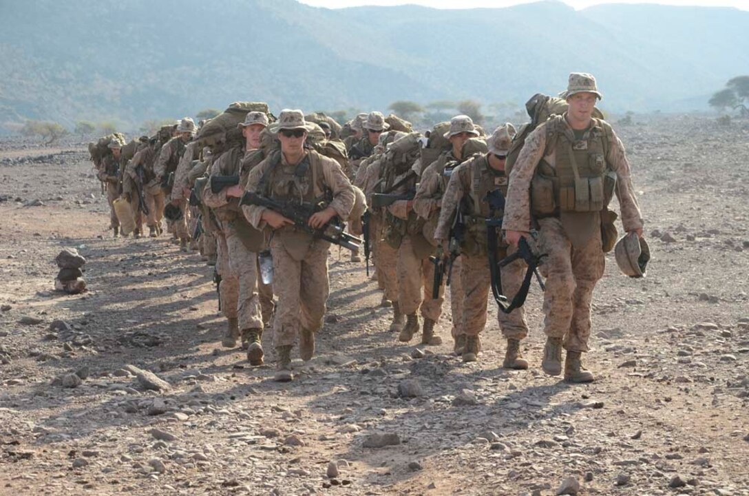 Marines assigned to 1st Platoon, Kilo Company, Battalion Landing Team 3/5, 15th Marine Expeditionary Unit (MEU), trek back to amphibious assault ship USS Peleliu (LHA 5) after completing an exercise at Arta Beach, Djibouti, Dec. 13. 15th MEU is deployed as part of the Peleliu Amphibious Ready Group as a U.S. Central Command theater reserve force, providing support for maritime security operations and theater security cooperation efforts in the U.S. 5th Fleet area of responsibility. (U.S. Marine Corps photo by Cpl. Richard P. Sanglap-Heramis/Released)