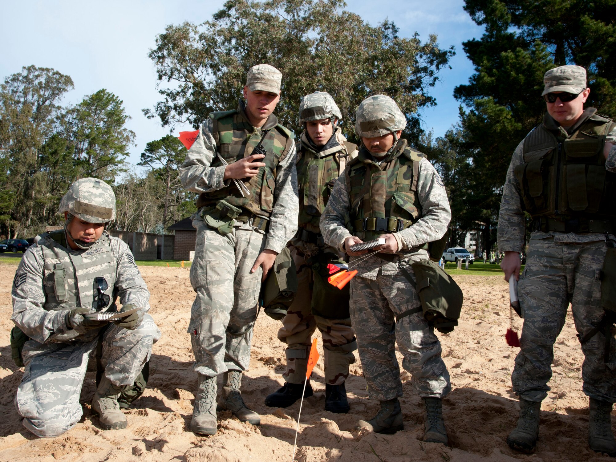 VANDENBERG AIR FORCE BASE, Calif. --  Vandenberg Airmen consult their Airmen’s Manuals and each other to report a partially buried Unexploded Ordinance during a practice for a Northstar exercise at Cocheo Park here Monday, Jan. 7, 2013. The Northstar exercise is designed to test the deployment capabilities and combat survival skills of Vandenberg Airmen. (U.S. Air Force photo/Senior Airman Lael Huss)
