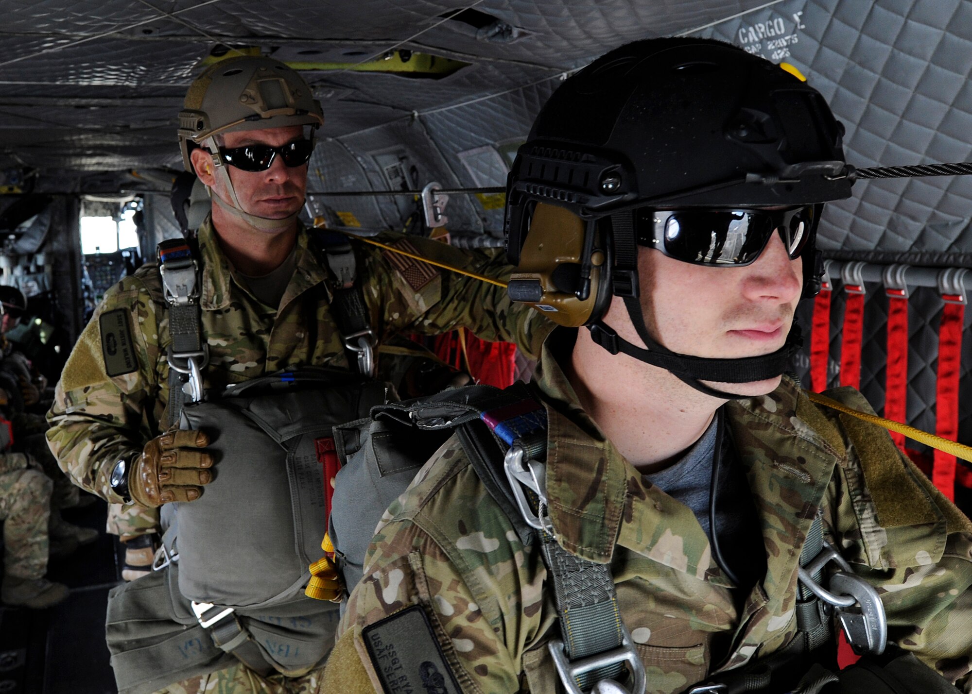 Staff Sgts. Ryan Kutch and Justin Wilkins wait inside a CH-47 Chinook helicopter moments before they perform a static-line jump above Fairchild Air Force Base, Wash., Nov. 6, 2012. A static line is a cord attached at one end to an aircraft and the other to the parachutist. As they fall from the aircraft, it causes the line to deploy their parachute. Kutch is a survival, evasion, resistance and escape specialist with the 22nd Training Group and Wilkins is a SERE specialist with the 66th Training Squadron. (U.S. Air Force photo by Airman 1st Class Ryan Zeski)
