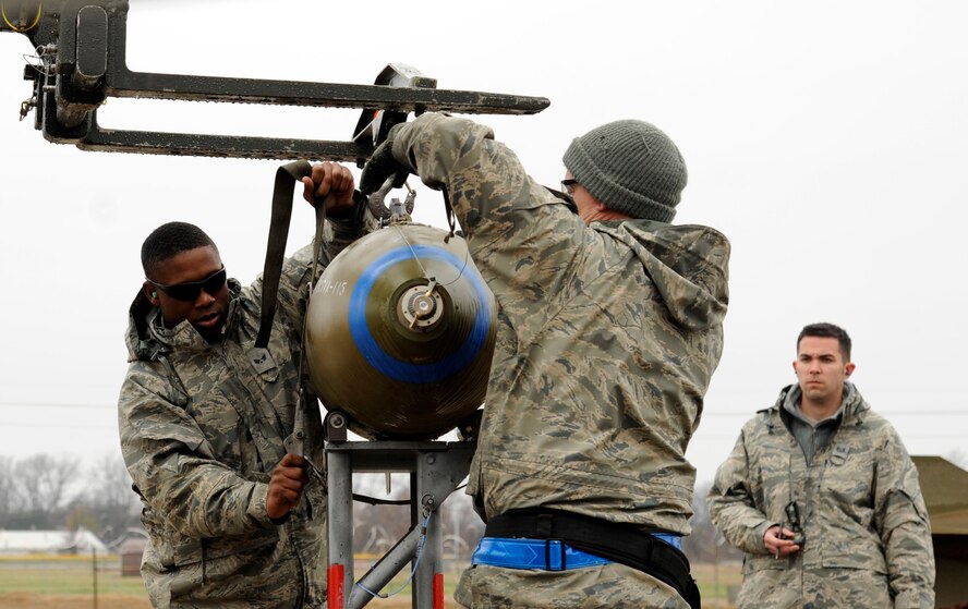 Senior Airman Akeem Bobo and Staff Sgt. Adolfo Trujillo, both of the 2nd Maintenance Group Weapons Standardization section, prepare an inert M117 general purpose bomb during a monthly proficiency requirement load, as Tech. Sgt. Kevin Little, 2nd MXG, observes on Barksdale Air Force Base, La., Jan. 8. MPRLs keep Airmen prepared for any situation where they have to load munitions in an organized, timely manner. (U.S. Air Force photo/Airman 1st Class Andrew Moua)
