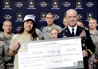 Maj. Gen. Jefforey A. Smith (right), commanding general of the U.S. Army Cadet Command and commanding general of Fort Dix, N.J., presents a four-year ROTC scholarship check to Cole High School senior Teresa Cenney during the U.S. Army All-American Bowl in the Alamodome Jan. 5. 
Photo by Sgt. 1st Class Carlos J. Lazo
