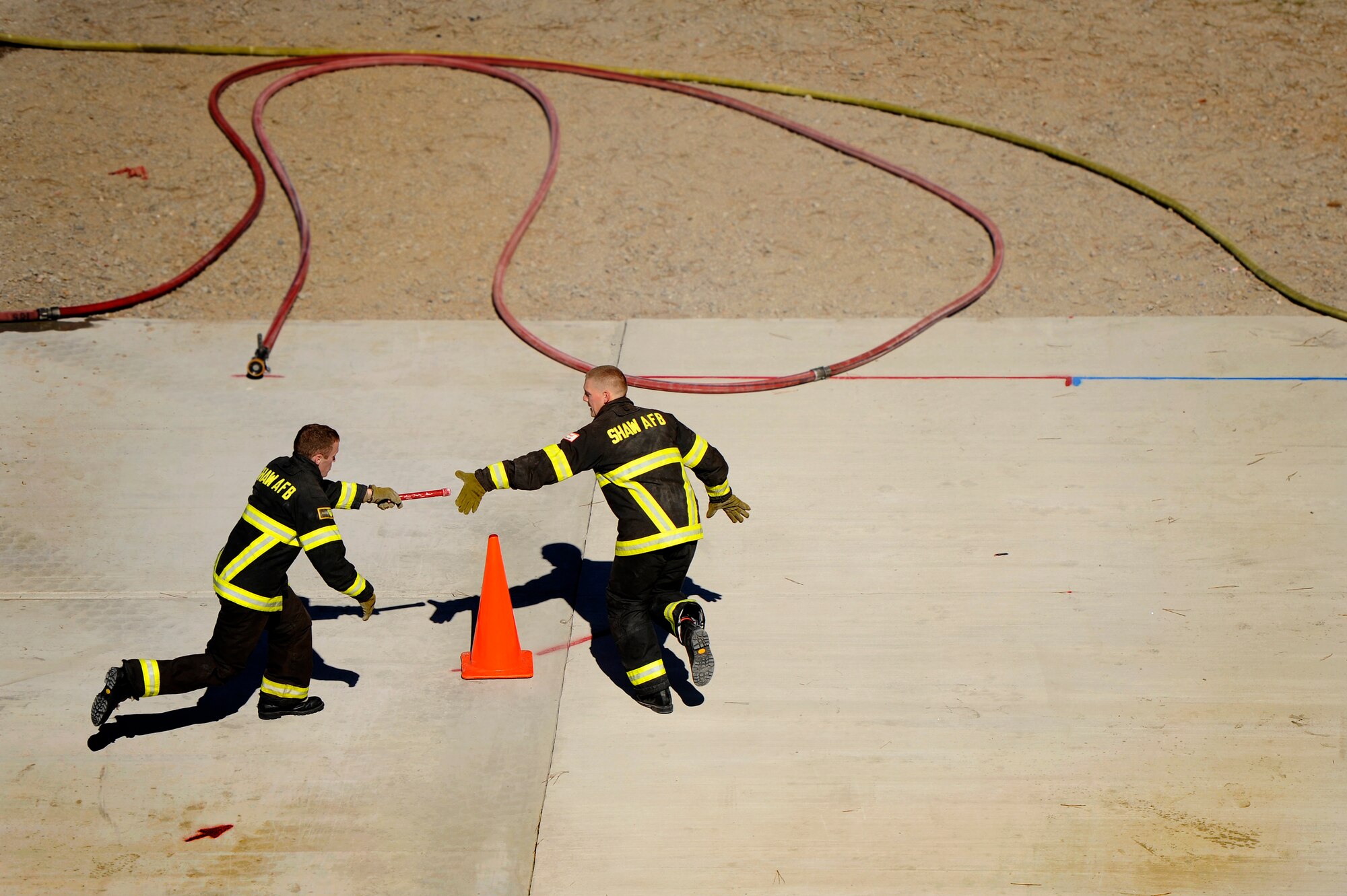Two Team Shaw 20th Civil Engineer Squadron firefighters pass off a baton while conducting relay training in preparation for the Scott Firefighter Combat Challenge worldwide competition in Myrtle Beach, S.C. Oct. 29, 2012 The competition took place Nov. 12 and 17, 2012 and Team Shaw’s firefighters took 6th place amongst the top 20 teams in the team portion of the competition. (U.S. Air Force photo by Staff Sgt. Kenny Holston/Released) 