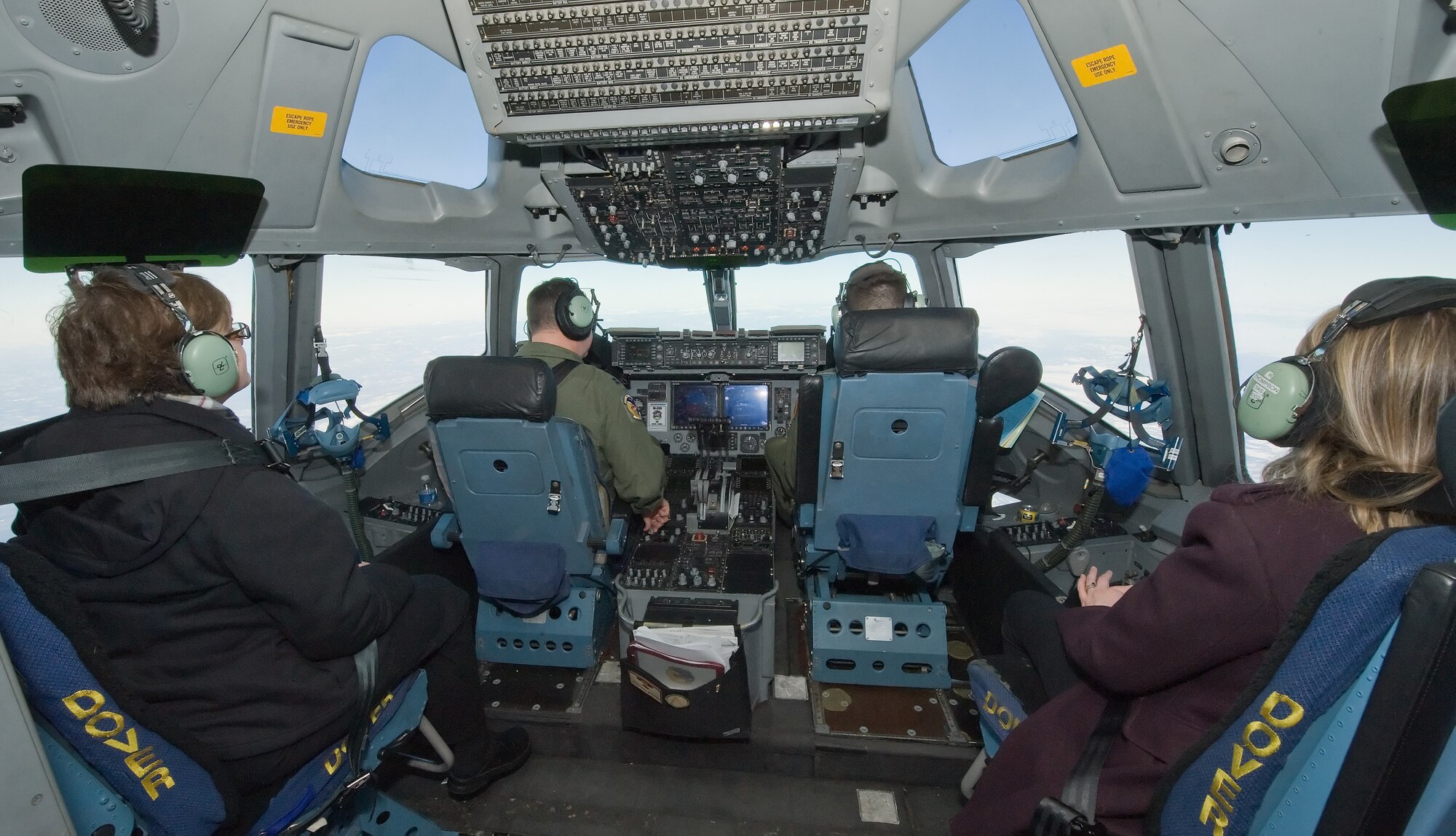 Devon Sorlie, left, and Kristin Davis, right, staff writers for the Air Force Times, observe Capts. James Blinn, left, and Jonathan Weaver, right, pilots with the 3rd Airlift Squadron, Dover Air Force Base, Del., perform in flight duties Jan. 7, 2013. Members of the media observed an air refueling mission with a KC-135R from the 101st Air Refueling Wing, Bangor, Maine. (U.S. Air Force photo/Roland Balik)
