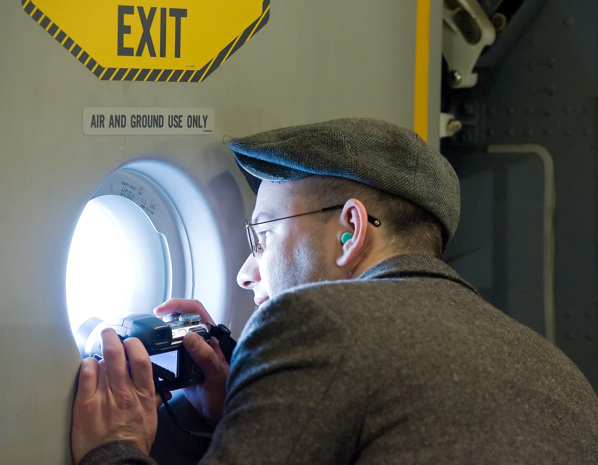 Joseph Leahy, a reporter from WDDE 91.1 FM radio in Dover, Del., takes a photo in flight out a C-17 Globemaster III side window Jan. 7, 2013. Mr. Leahy and 11 other members of the media participated in the media day event to familiarize local media representatives with daily operations and training at Dover Air Force Base, Del.. (U.S. Air Force photo/Roland Balik)