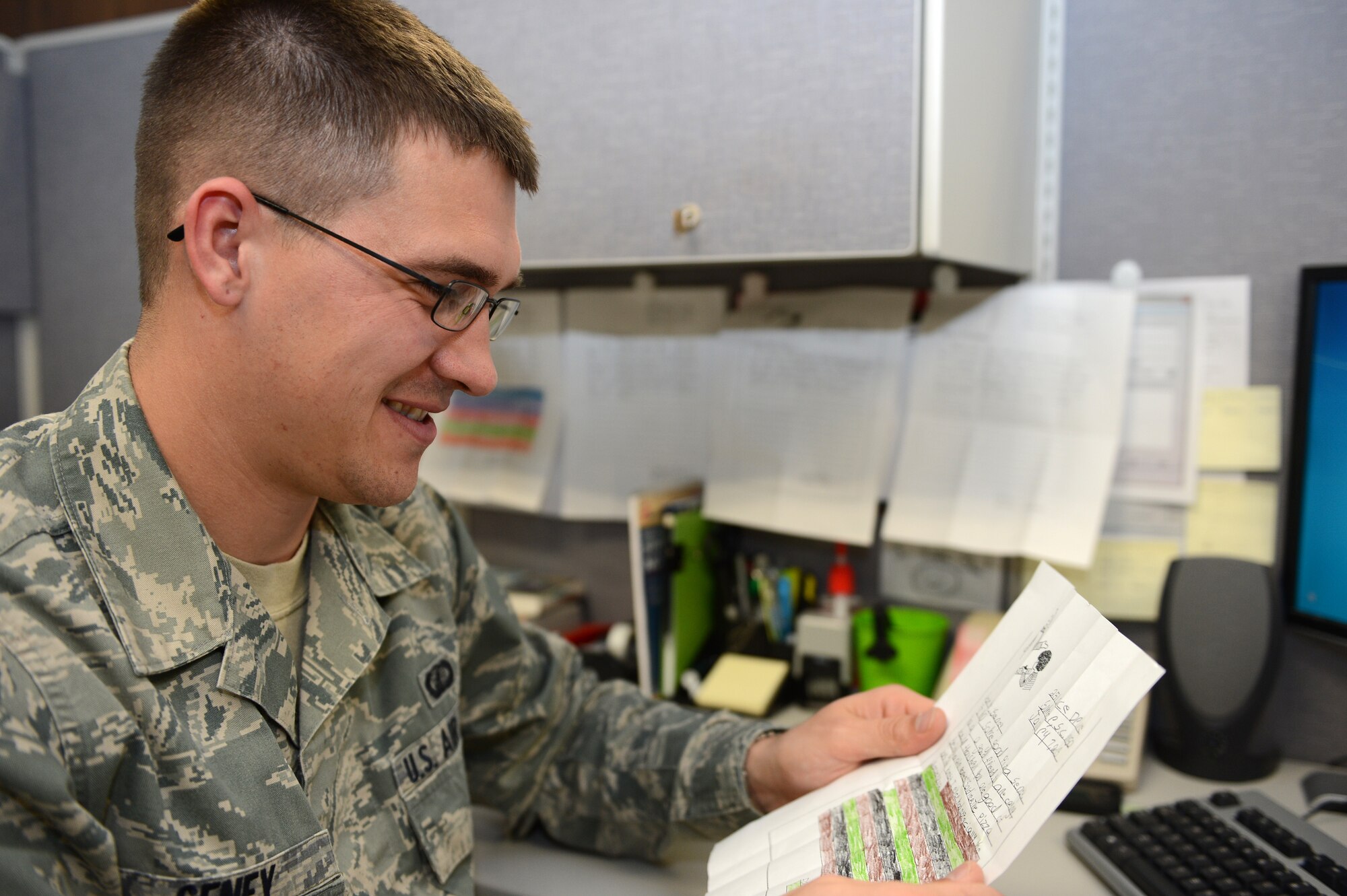 Senior Airman Kevin Seney, 20th Comptroller Squadron special actions technician, reads over a thank you letter from Robert, a child he mentors weekly at Alice Drive Elementary School, Shaw Air Force Base, S.C., Jan. 08, 2013. Mentoring Robert, along with other volunteer and education expanding opportunities helped Seney achieve Senior Airman below-the-zone. (U.S. Air Force photo by Airman 1st Class Daniel Blackwell)