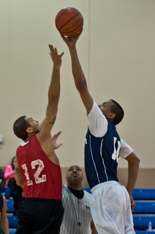 Airmen from the 799th Air Base Squadron and 57th Maintenance Squadron jump for the ball during the opening jump ball during an intramural basketball game, Jan. 7, 2013, in the Warrior Fitness Center at Nellis Air Force Base, Nev.  The league has 27 teams which are broken down into three divisions with nine teams in each division.  (U.S. Air Force Photo by Senior Airman Daniel Hughes)