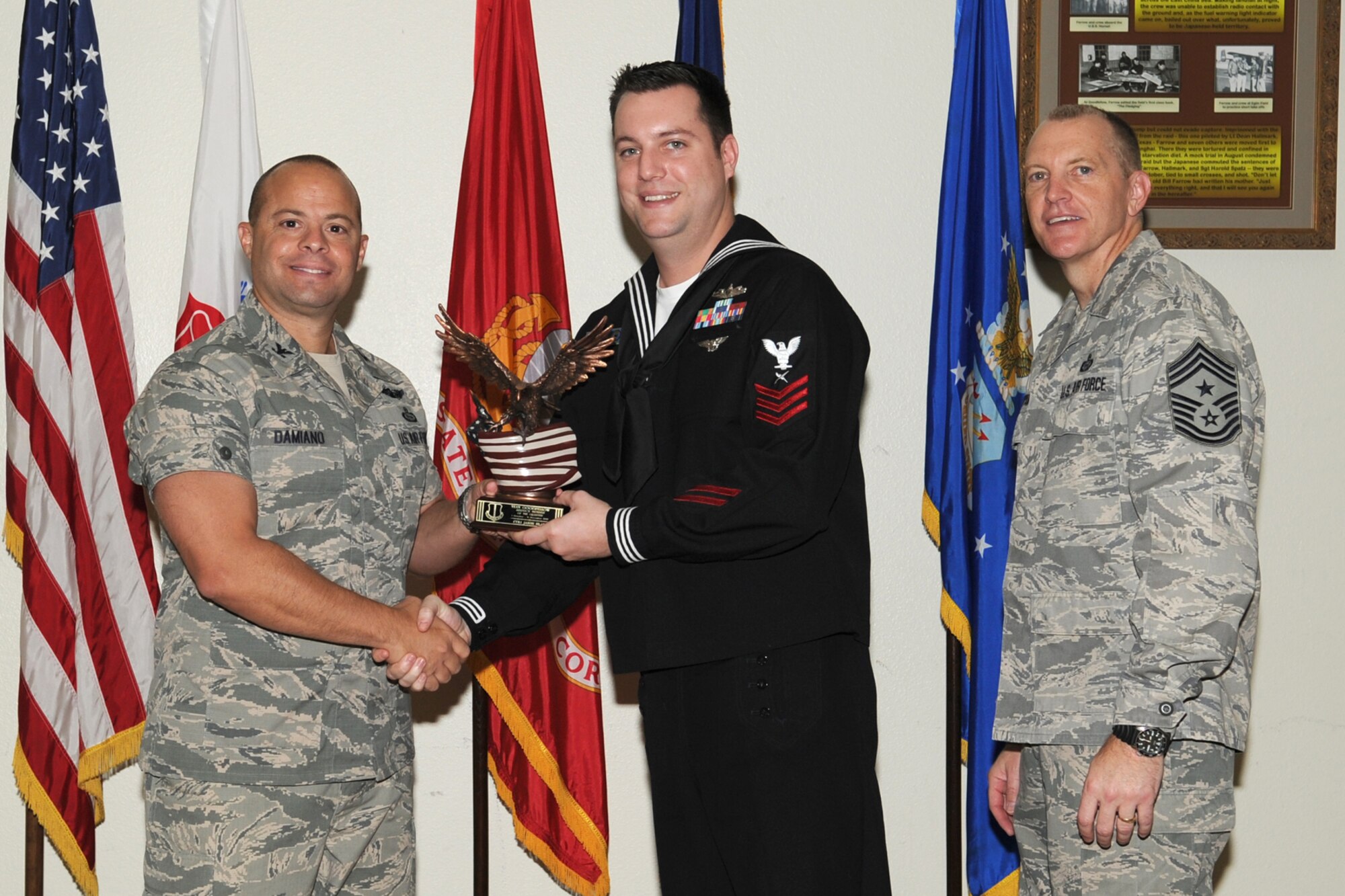 GOODFELLOW AIR FORCE BASE, Texas- Col. Mark Damiano, 17th Training Wing Commander and Chief Master Sgt. Scott Lumpkin, 17th TRW Command Chief, present the Team Goodfellow Servicemember of the Quarter award to Navy Petty Officer 1st Class Jason Hlad, Navy Center for Information Dominance Detachment, during the wing quarterly awards ceremony here, Jan. 8. (U.S. Air Force photo/  Staff Sgt. Laura R. McFarlane)