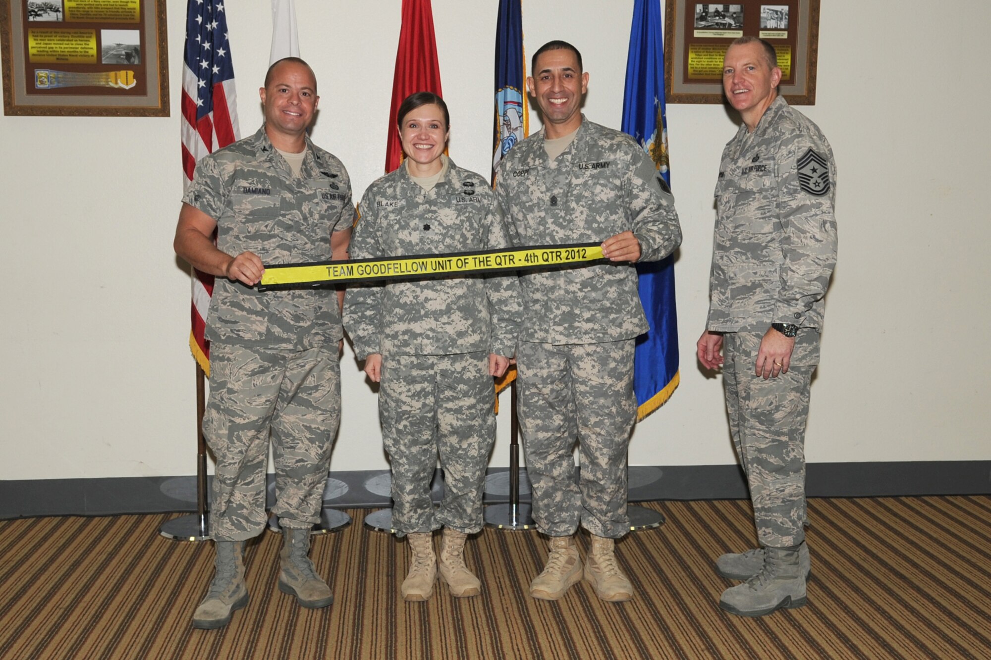 GOODFELLOW AIR FORCE BASE, Texas- Col. Mark Damiano, 17th Training Wing Commander and Chief Master Sgt. Scott Lumpkin, 17th TRW Command Chief, present the Team Goodfellow Unit of the Quarter streamer to Army Lt. Col. Devon Blake, 344th Military Intelligence Battalion commander and Command Sgt. Maj. Matildo Coppi, during the wing quarterly awards ceremony here, Jan. 8. (U.S. Air Force photo/ Staff Sgt. Laura R. McFarlane)