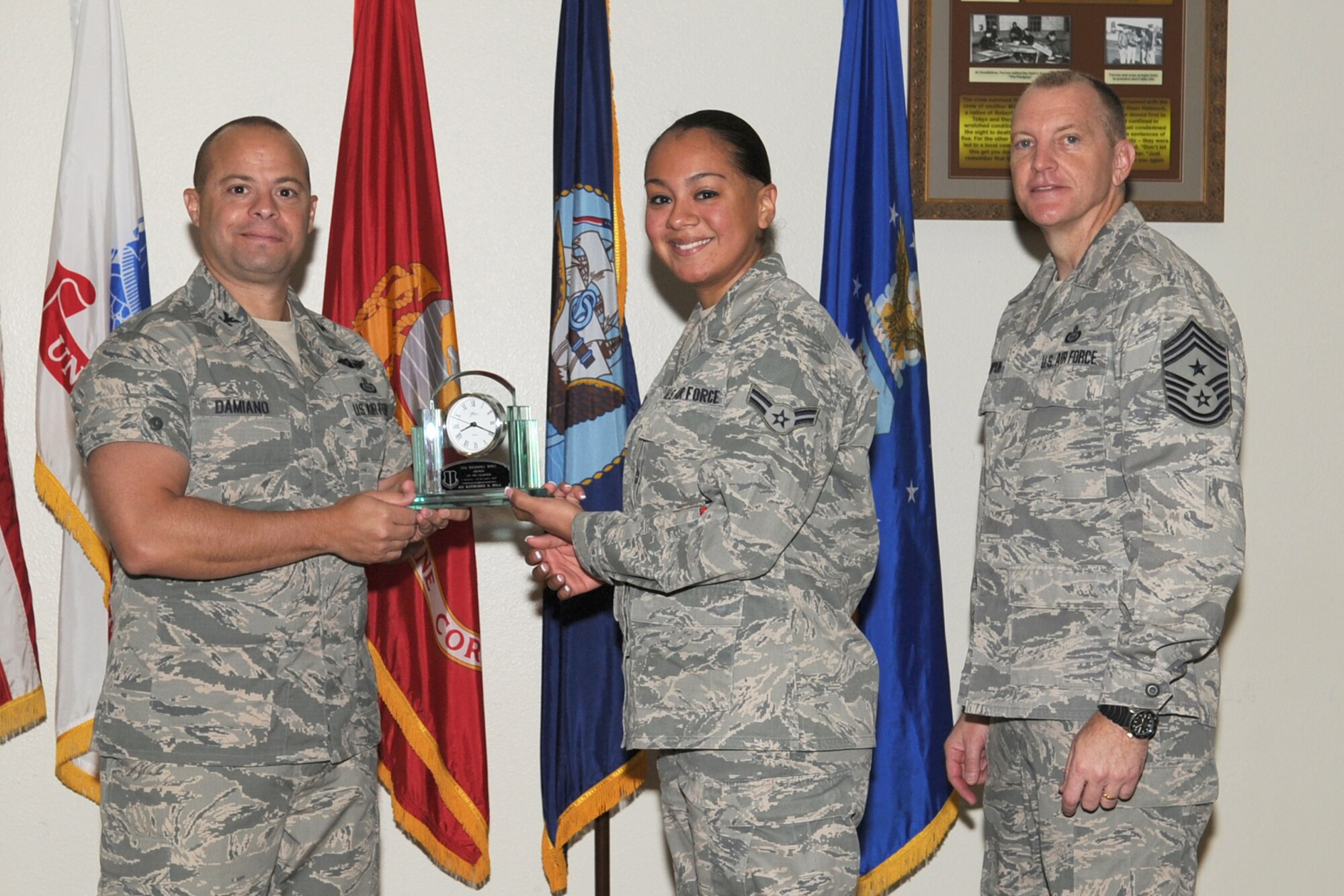 GOODFELLOW AIR FORCE BASE, Texas--  Col. Mark Damiano, 17th Training Wing Commander and Chief Master Sgt. Scott Lumpkin, 17th TRW Command Chief, present the 17th Training Wing Airman of the Quarter to Airman 1st Class Katherine Vela, 17th Medical Support Squadron, during the wing quarterly awards ceremony, here, Jan. 8. (U.S. Air Force photo/Staff Sgt. Laura R. McFarlane)