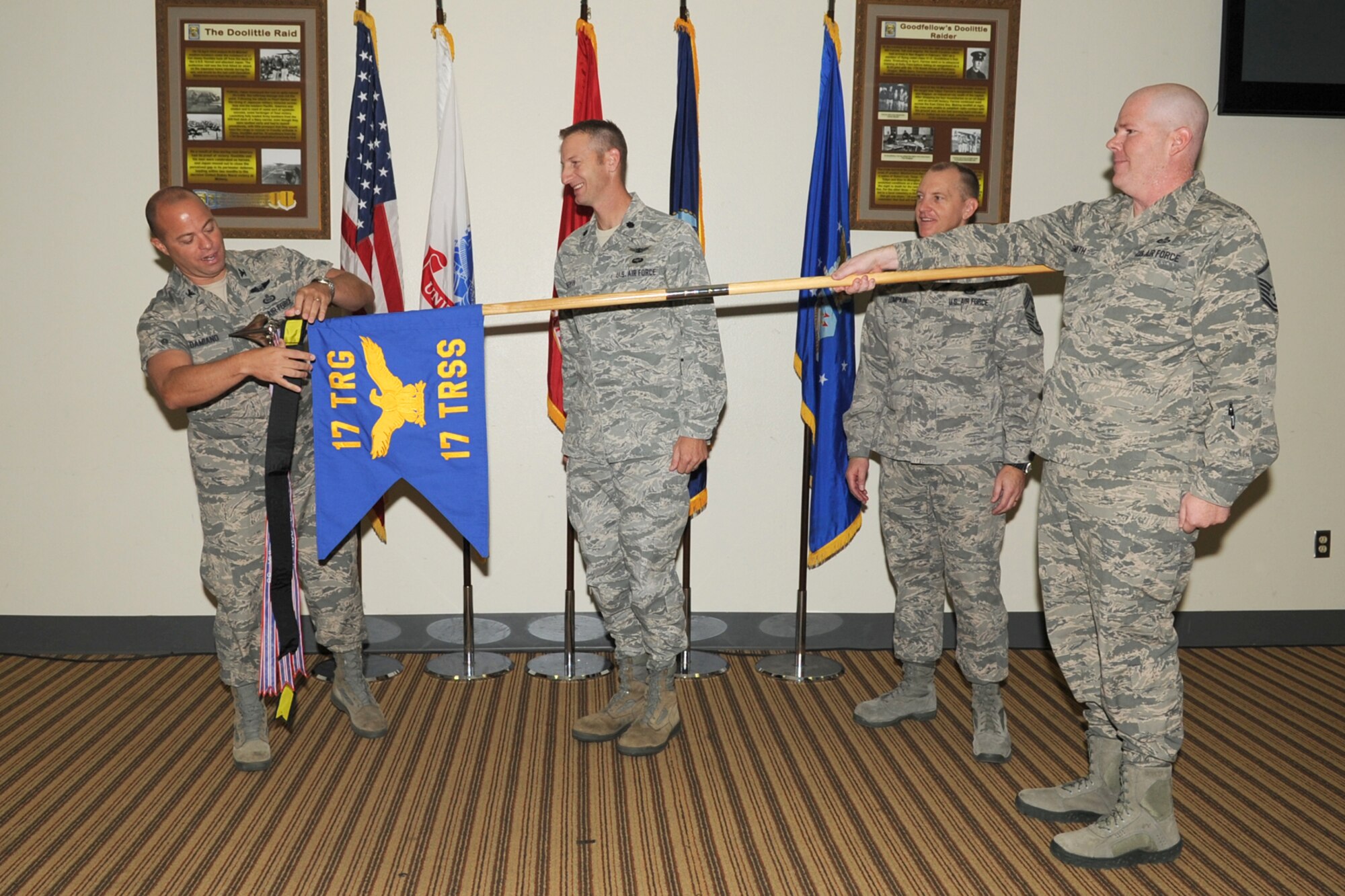 GOODFELLOW AIR FORCE BASE, Texas-- Col. Mark Damiano, 17th Training Wing Commander and Chief Master Sgt. Scott Lumpkin, 17th TRW Command Chief, place the 17th Training Wing Unit of the Quarter streamer on the 17th Training Support Squadron guidon during the wing quarterly awards ceremony,here, Jan. 8. (U.S. Air Force photo/Staff Sgt. Laura R. McFarlane)