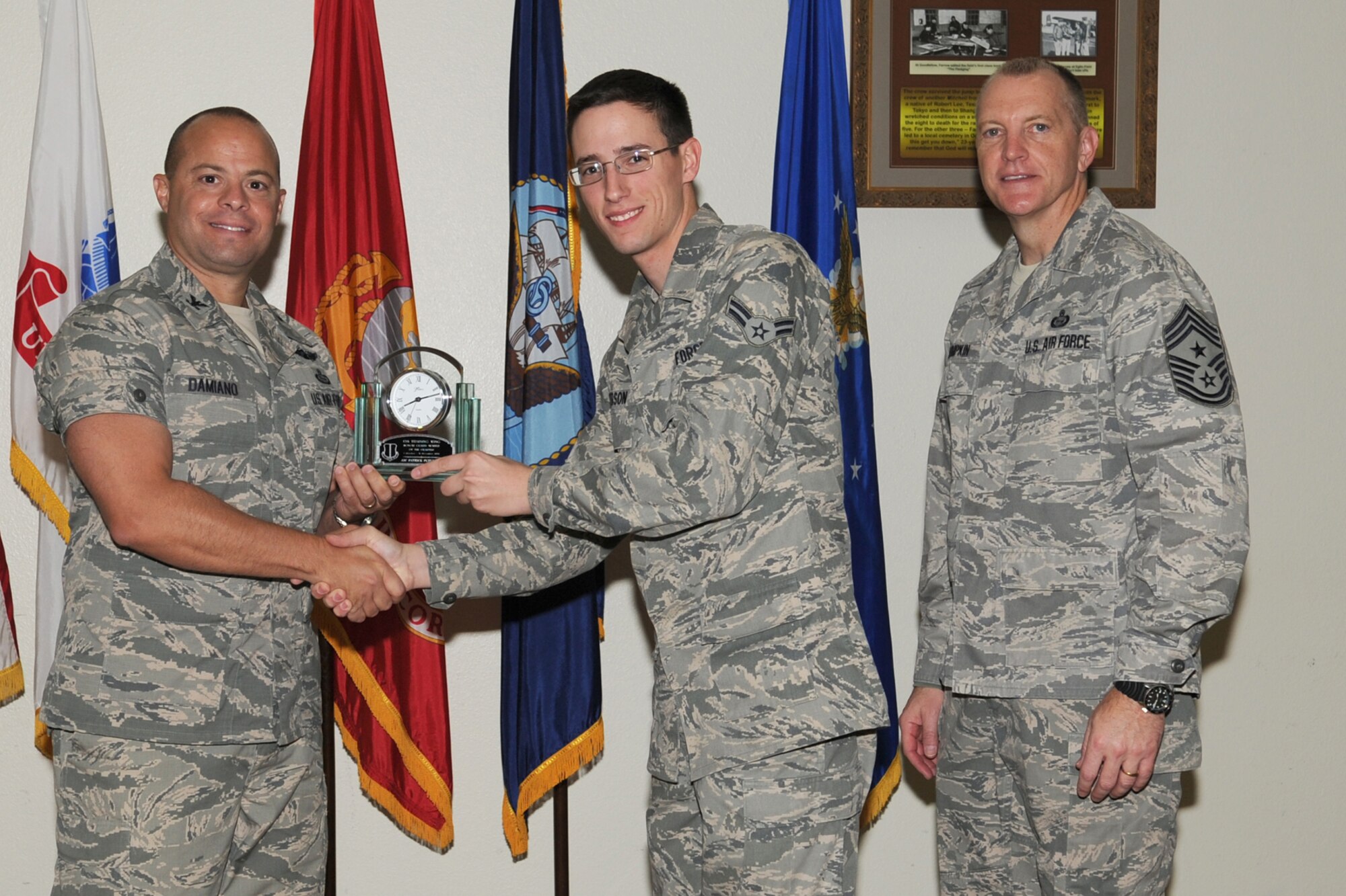 GOODFELLOW AIR FORCE BASE, Texas--  Col. Mark Damiano, 17th Training Wing Commander and Chief Master Sgt. Scott Lumpkin, 17th TRW Command Chief, present the 17th Training Wing Honor Guard of the Quarter to Airman 1st Class Patrick Peterson, 17th Communications Squadron, during the wing quarterly awards ceremony, here, Jan. 8. (U.S. Air Force photo/Staff Sgt. Laura R. McFarlane)