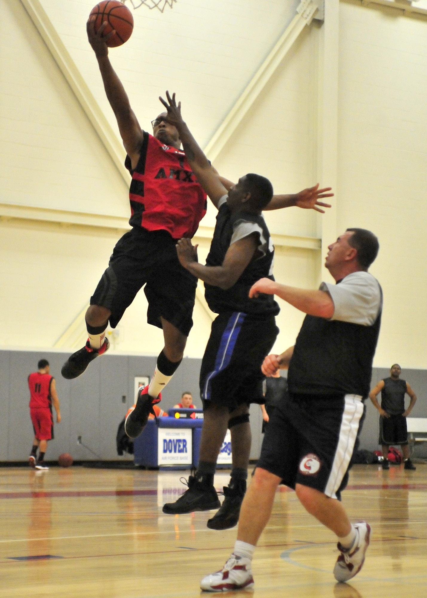 Duncan Willie, 736th Aircraft Maintenance Squadron player-coach, jumps for a layup as 512th Airlift Wing defenders attempt to block during an intramural basketball game Jan. 7, 2013, at the fitness center on Dover Air Force Base, Del. Willie scored 17 points to help lead the 736th AMXS to a 58-55 overtime victory. (U.S. Air Force photo by Tech. Sgt. Chuck Walker)
