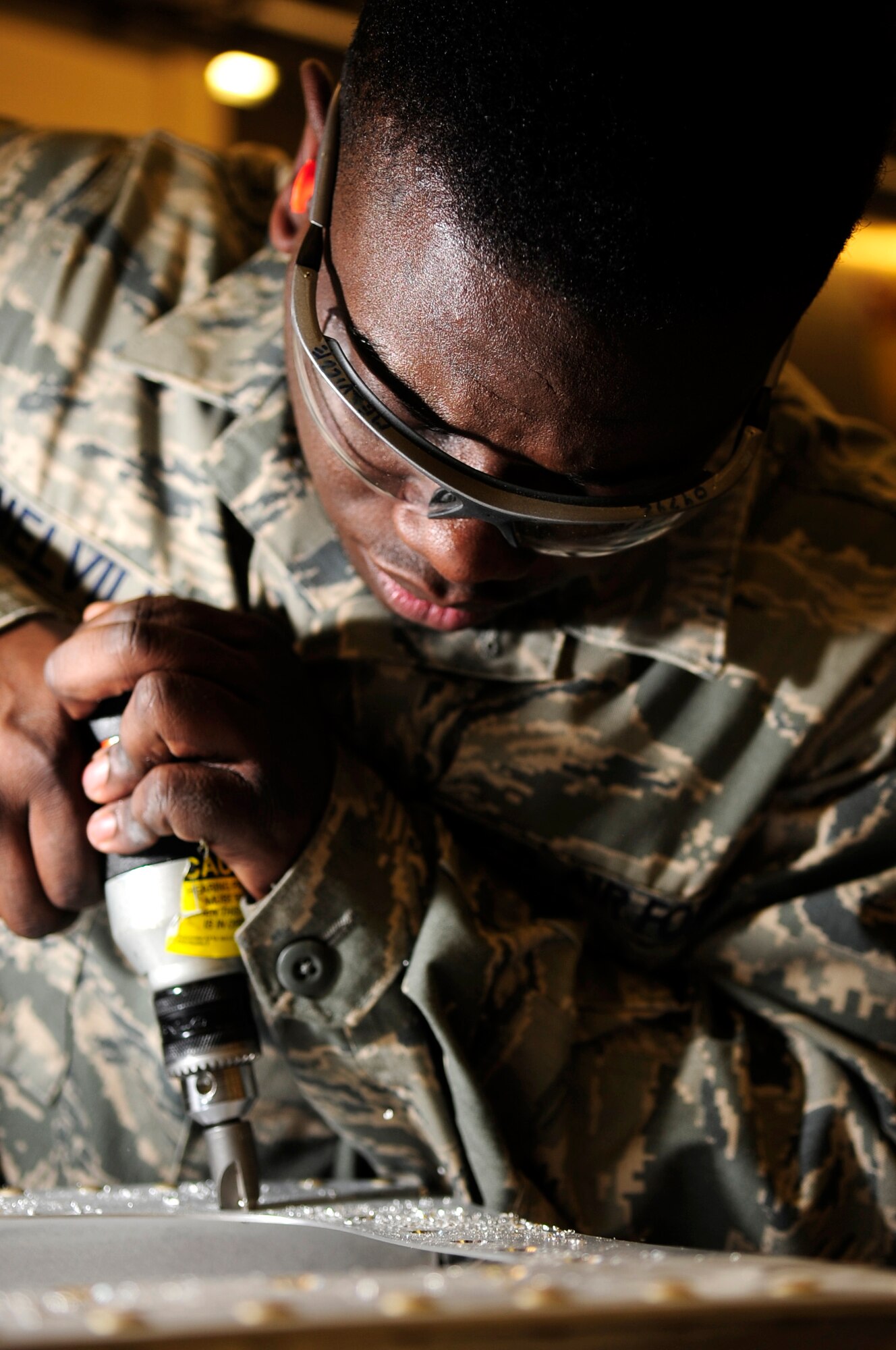 Senior Airman Theo Melville, 100th Maintenance Squadron aircraft structural maintainer from Princeton, N.J., bores holes into a piece of sheet metal for a training project at the sheet metal shop Jan. 8, 2013, on RAF Mildenhall, England. There are 35 Airmen assigned to the shop who are responsible for producing materials for various repairs on aircraft parts. (U.S. Air Force photo by Airman 1st Class Dillon Johnston/Released)
