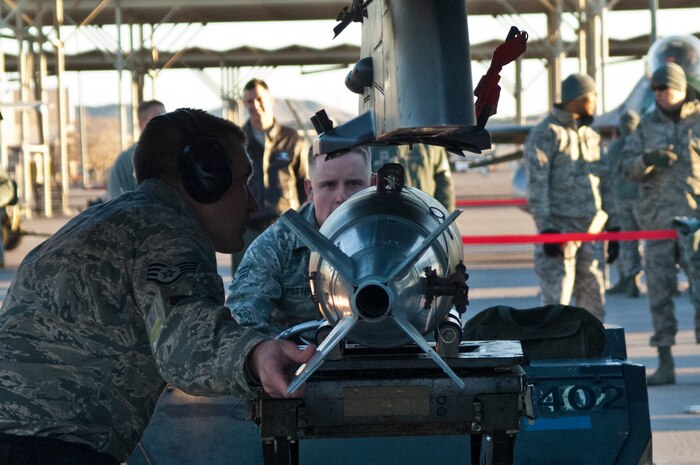 Staff Sgt. Bryan Bradbury and Senior Airman Jesse Potter, 57th Aircraft Maintenance Squadron aircraft armament systems technicians, upload a guided bomb unit to an F-16 Fighting Falcon, Jan. 4, 2013, at Nellis Air Force Base, Nev. The quarterly load crew competition helps promote teamwork and morale. (U.S. Air Force Photo by Airman 1st Class Monet Villacorte)