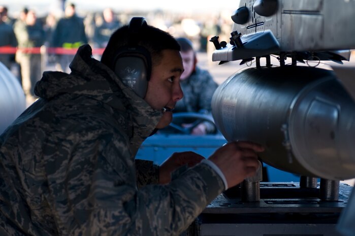 Airman 1st Class Ryan Duarte, 57th Aircraft Maintenance Squadron weapons load crew member, loads an Mk-82 bomb to an F-16 Fighting Falcon, during a quarterly load crew competition, Jan. 4, 2013, at Nellis Air Force Base, Nev. The Airmen are graded on a written test, dress and appearance, their composite tool kit, and the load. (U.S. Air Force photo by Senior Airman Matthew Lancaster)
