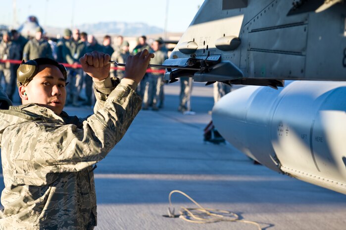 Airman 1st Class Ryan Duarte, 57th Aircraft Maintenance Squadron weapons load crew member, prepares an F-16 Fighting Falcon to be uploaded with weapons, during a quarterly load crew competition, Jan. 4, 2013, at Nellis Air Force Base, Nev. Airmen that compete are chosen by their section chiefs based on job performance. (U.S. Air Force photo by Senior Airman Matthew Lancaster)