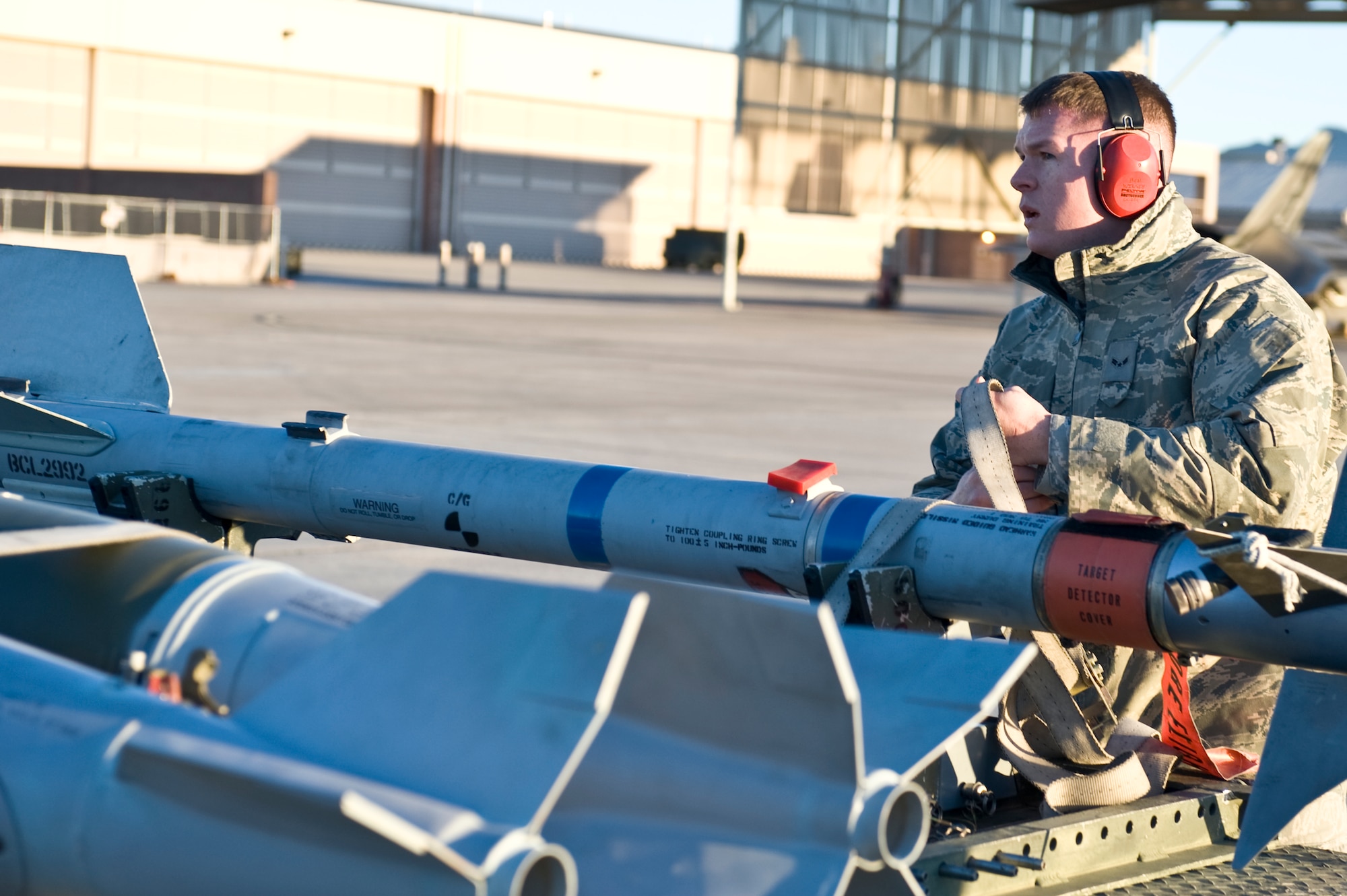 Airman 1st Class Ben Wilsey, 57th Aircraft Maintenance Squadron weapons load crew member, prepares to load an AIM-9 Sidewinder to an F-16 Fighting Falcon during a quarterly load crew competition,  Jan. 4, 2013, at Nellis Air Force Base, Nev. Weapons load teams are evaluated for use of the checklist, safety, and overall speed.  (U.S. Air Force photo by Senior Airman Matthew Lancaster)
