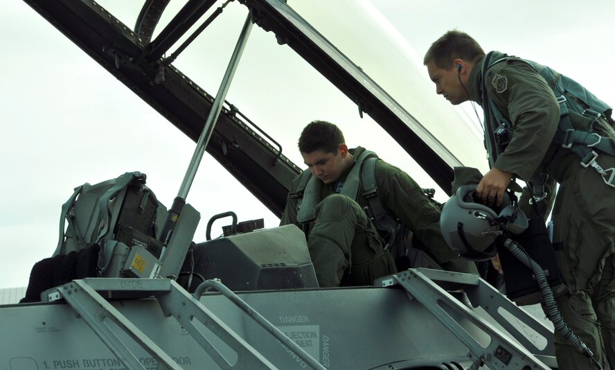 Air Force Academy Cadet Patrick Lobo (left) squeezes in the cockpit of on an F-16 as Lt. Col. Adam Meyers, 93rd FS F-16 pilot, gives pre-flight instructions before takeoff for Lobo's F-16 orientation flight at Homestead Air Reserve Base, Fla., Dec. 21. Six Air Force Academy cadets, during their winter break, participated in orientation flights, flying in the backseat of an F-16 with pilots from the 93rd Fighter Squadron at Homestead Air Reserve Base, Fla., Dec. 17 through 21. Academy cadets are authorized an opportunity to ride on certain aircraft, Air Force wide, during a regularly scheduled training mission as a way of familiarizing them with the occupational Air Force. (U.S. Air Force photo/Senior Airman Jaimi Upthegrove)