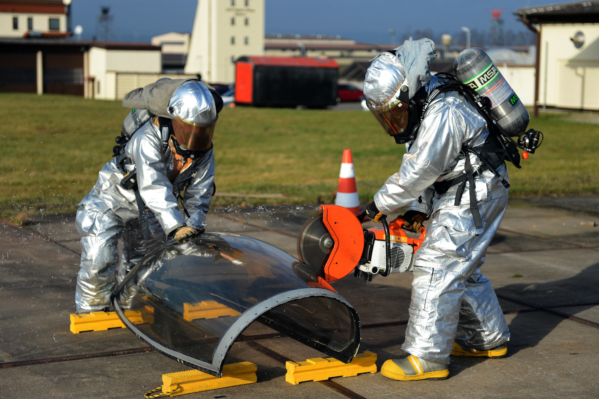 SPANGDAHLEM AIR BASE, Germany – A 52nd Civil Engineer Squadron firefighter cuts into an aircraft canopy while his teammate stabilizes the canopy, Jan. 7, 2013. Firefighters train several times a year emergency egress tactics. (U.S. Air Force photo by Airman 1st Class Dillon Davis/Released)