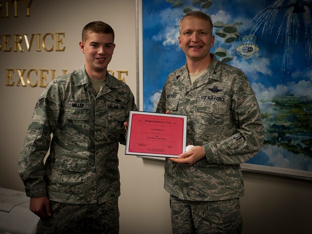 Senior Airman Herschell Miller, 437th Airlift Wing Maintenance Squadron, Precision Measurement Equipment Laboratory technician , presents Col. Darren Hartford, 437th Airlift Wing commander, the award for most spicy chili during the Commanders Chili Cook-off Jan. 4, 2012, at Joint Base Charleston – Air Base, S.C. Commanders from several JB Charleston commands participated by bringing in their own style of chili and opened the event for Airmen to sample their creations. All proceeds from the cook-off went to Airmen Against Drunk Driving. (U.S. Air Force photo/Airman 1st Class Tom Brading)