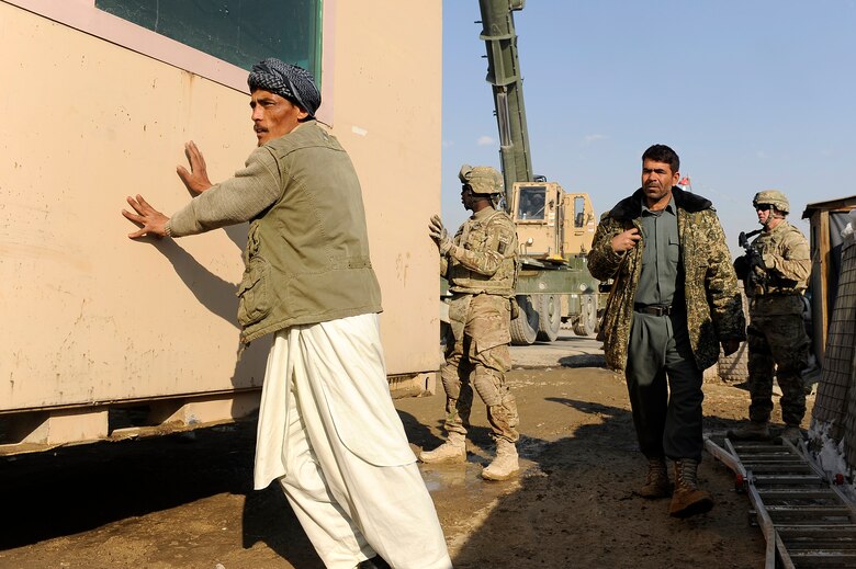 U.S. Airmen and Soldiers work with Afghan National Police members to position a new guard post near Bagram Airfield, Jan 6, 2013.  Airmen from the 455th Expeditionary Security Forces Group teamed with the Army’s 857th Engineer Company and local ANP forces to transfer an armored guard post from Bagram to a nearby ANP checkpoint. (U.S. Air Force photo/Capt. Erika Yepsen)