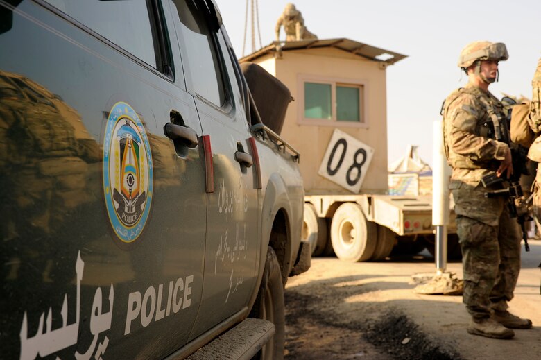 Airmen from the 455th and 755th Expeditionary Security Forces Squadron stand guard while Soldiers from the 857th Engineer Company prepare to move an armored guard post, Jan. 6, 2013. Airmen and Soldiers from Bagram Airfield partnered with local Afghan National Police forces to transfer the building to a nearby ANP checkpoint. (U.S. Air Force photo/Capt. Erika Yepsen)