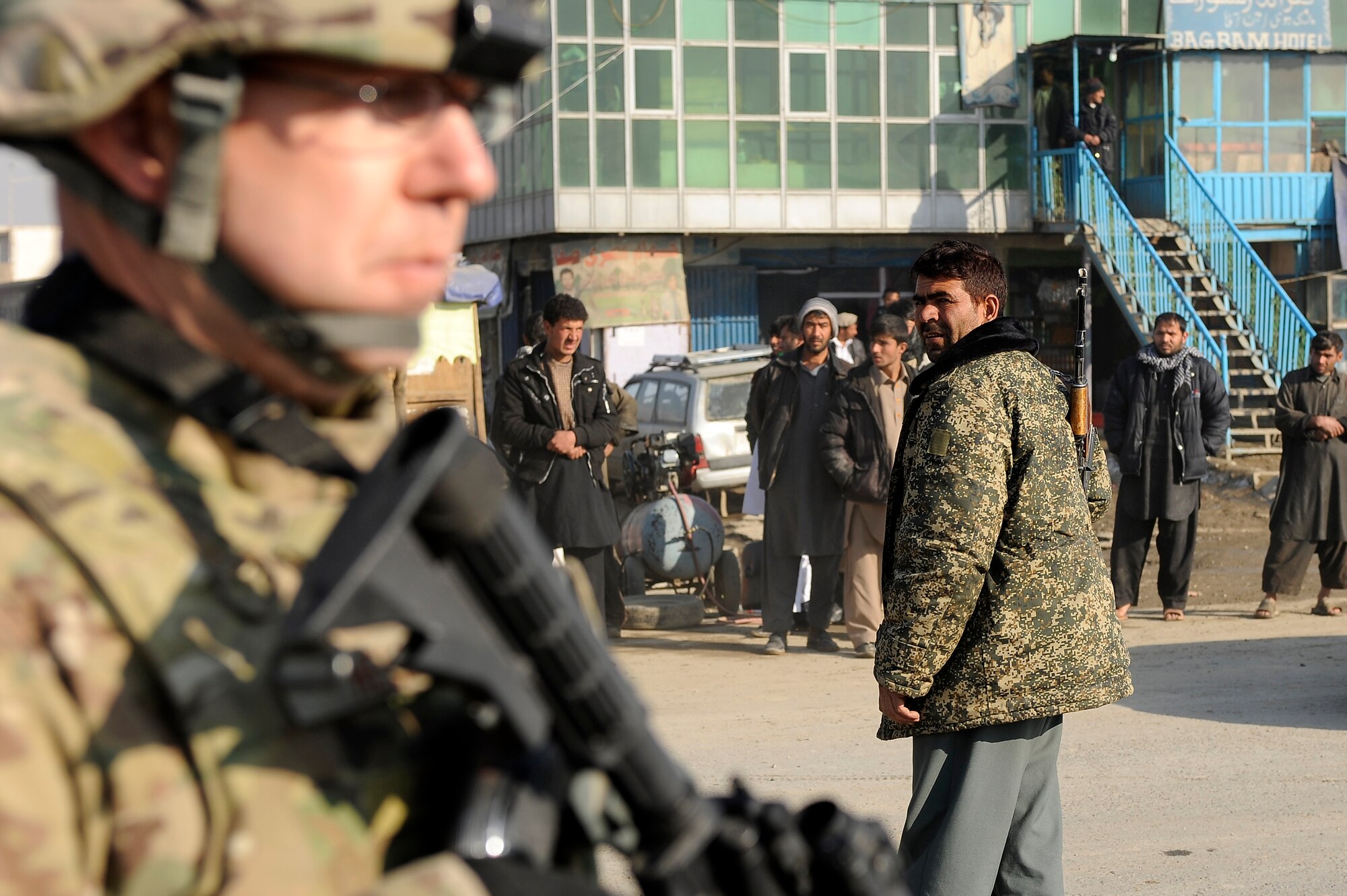 Air Force Tech. Sgt. John Helms, 455th Expeditionary Security Forces Squadron, and a counterpart from the Afghan National Police provide security as Army engineers position a new guard post, Jan. 6, 2013.  Airmen from the 455th Expeditionary Security Forces Group teamed with the Army’s 857th Engineer Company and local ANP forces to transfer an armored guard post from Bagram to a nearby ANP checkpoint. (U.S. Air Force photo/Capt. Erika Yepsen)