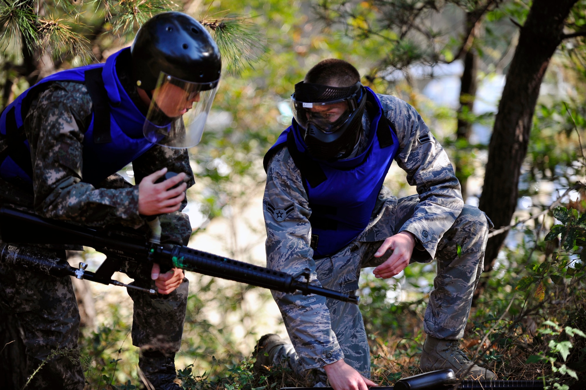 Private Second Class Kim, Saehoon (left), Republic of Korean Army 4th Battalion 169th Regiment soldier, and Airman 1st Class Jacob Ford, 51st Security Forces Squadron defender and Quick Reaction Team member, discuss tactics in a joint training paintball exercise Nov. 1, 2012. The training helped familiarize tactics from both units by integrating teams for a friendly, competitive game of capture the flag. (U.S. Air Force photo/Airman 1st Class Alexis Siekert)