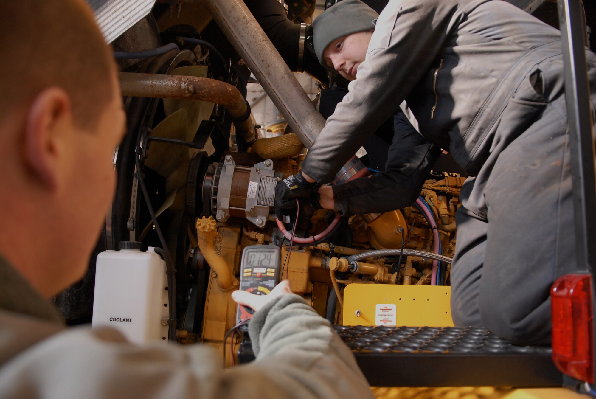Airman 1st Class Jared France, 8th Logistic Readiness Squadron vehicle maintenance technician verifies the alternator of a 25-ton snow sweeper is receiving the correct amount of voltage on Kunsan Air Base, Republic of Korea, Dec. 11, 2012. France was assisted by Senior Airman Nicholas Lamendola, 8th LRS fire-truck maintenance technician, who help repair the vehicles used by the 8th Civil Engineer Squadron to clear the base of snow. (US Air Force photo by Staff Sgt. Tong Duong/ released)