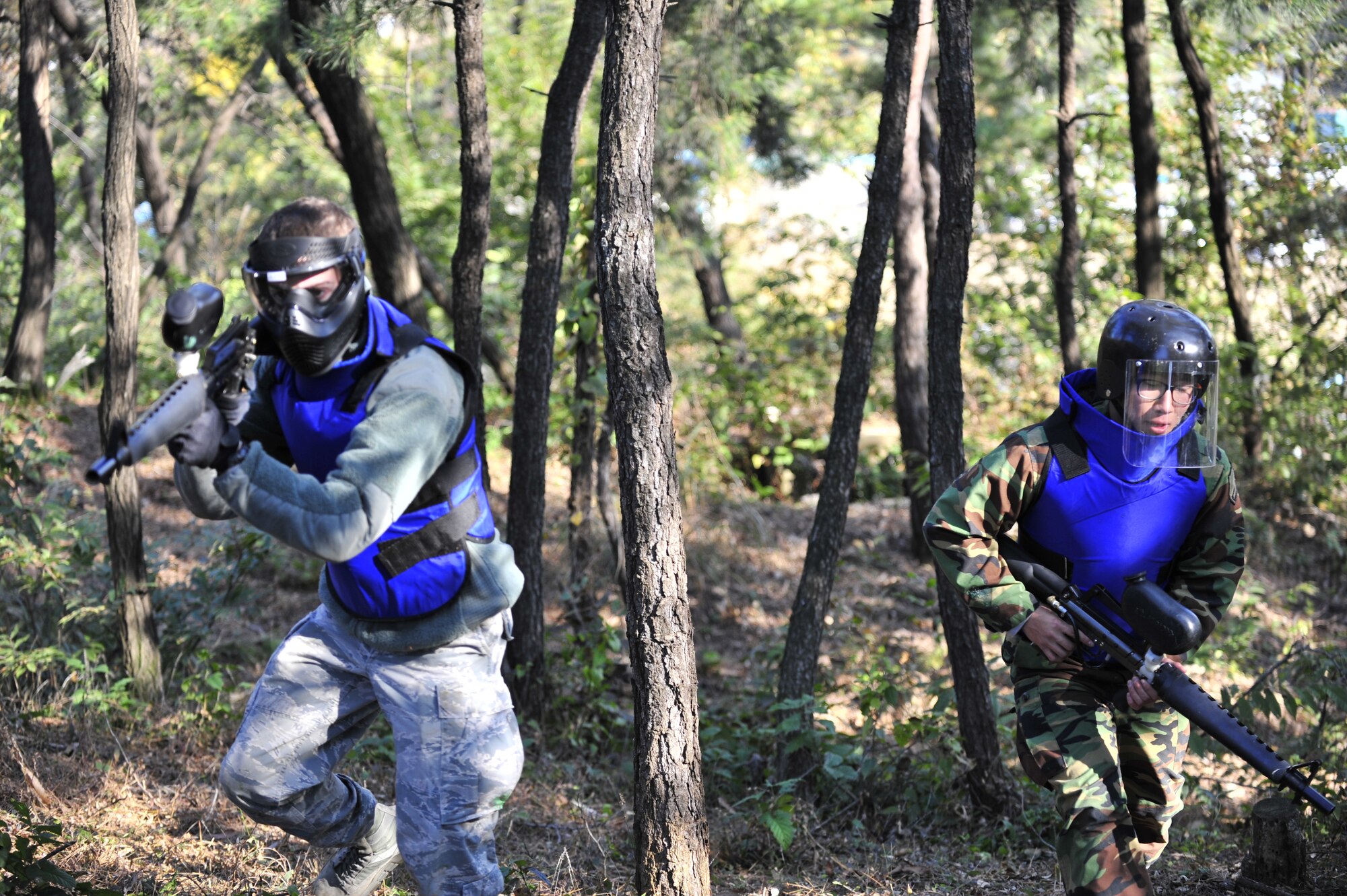 Airman 1st Class Stephen Brindle (left), 51st Security Forces Squadron defender and Quick Reaction Team member, and Cpl. Ahn, Daehyun, Republic of Korean Army 4th Battalion 169th Regiment soldier, cover ground in a joint training paintball exercise Nov. 1, 2012. The training was hosted by the Republic of Korean Army 4th Battalion 169th Regiment at their headquarters. (U.S. Air Force photo/Airman 1st Class Alexis Siekert)