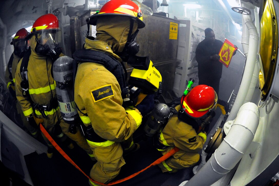 U.S. Navy Petty Officer 1st Class Leland Bryant, right, simulates a fire as sailors practice firefighting techniques during a drill aboard the USS Jason Dunham while under way at sea in the U.S. 5th Fleet area of responsibility, Jan. 4, 2013. Bryant is a fire controlman.
