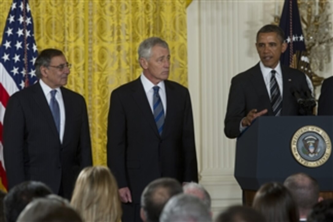 Secretary of Defense Leon E. Panetta, left, and former Sen. Chuck Hagel, center, listen as President Barack Obama addresses the audience at the nomination announcement for Hagel as the next secretary of defense in the East Room of the White House on Jan. 7, 2013.  