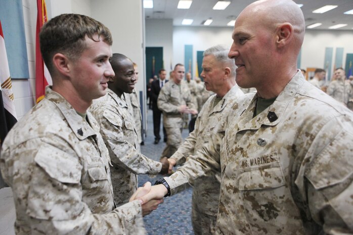 Sergeant Major of the Marine Corps, SgtMaj. Micheal P. Barrett, shakes hands with Sgt. Cody Marshall as he presents him with a challenge coin while visiting Marines serving in Bahrain, Dec. 27. The Commandant of the Marine Corps, Gen. James F. Amos, and the SMMC visited Marines throughout the U.S. Central Command's area of responsibility over the holidays.