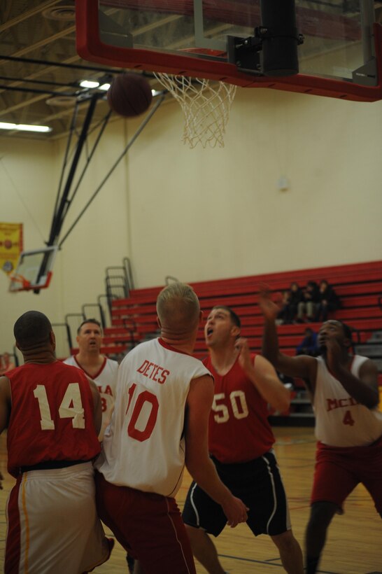 Players from Enlistment Incentive Program’s and Marine Corps Intelligence Activities’ intramural basketball teams wait for the rebound during the first game of the season at Barber Physical Fitness Center on Monday. MCIA had a steady lead in the first half of the game and held on to win, 42-22. 