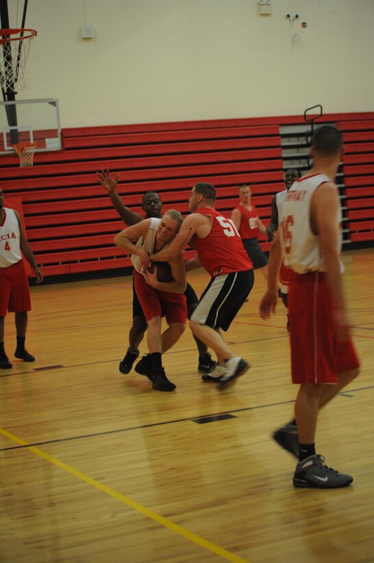 Jason Detes, player, Marine Corps Intelligence Activities intramural basketball team, fights for a jump ball with Enlistment Incentive Program’s intramural basketball player Shaun Deitzel during the first game of the intramural basketball season at the Barber Physical Fitness Center on Monday. MCIA’s fight and defense won the game, 42-22. 