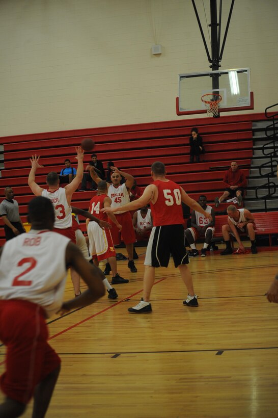 Armando Ramirez, player, Marine Corps Intelligence Activities intramural basketball team, passes the ball to Josh Buchholz, head coach, MCIA, during the first game of the season against Enlistment Incentive Program at the Barber Physical Fitness Center on Monday. MCIA took the win, 42-22.