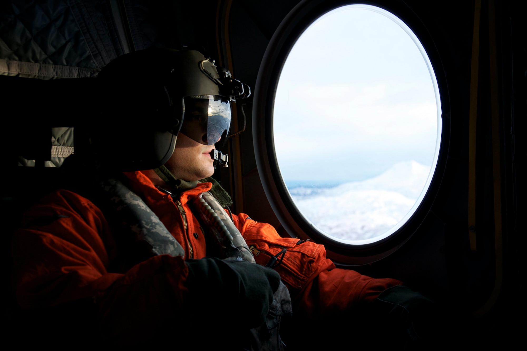 Pfc Ryan Yetman watches out a side window for potential hazards as his CH-47F helicopter flies toward the Kodiak coast Jan. 7. Two CH-47F Chinook helicopters from B Company, 1st Battalion, 52nd Aviation Regiment flew to Kodiak on a mission to help the grounded oil rig Kulluk by hauling equipment to and from the rig. (U.S. Air Force photo/SSgt. Aaron M. Johnson)