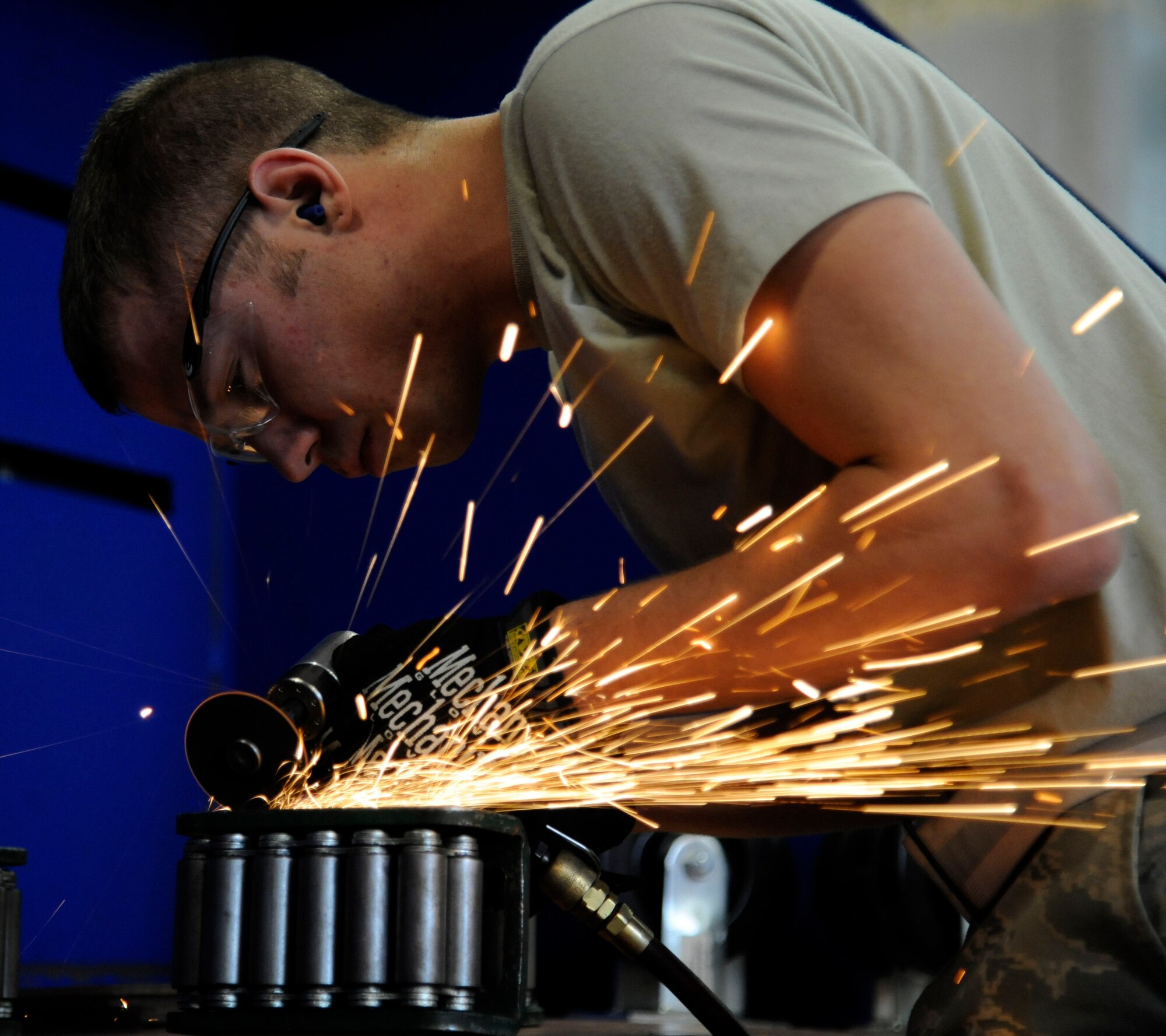 Airman 1st Class David Reid, 2nd Maintenance Squadron fabrication flight, grinds down machine rollers on Barksdale Air Force Base, La., Jan. 9. The rollers are used to move heavy machinery. (U.S. Air Force photo/Airman 1st Class Andrew Moua)