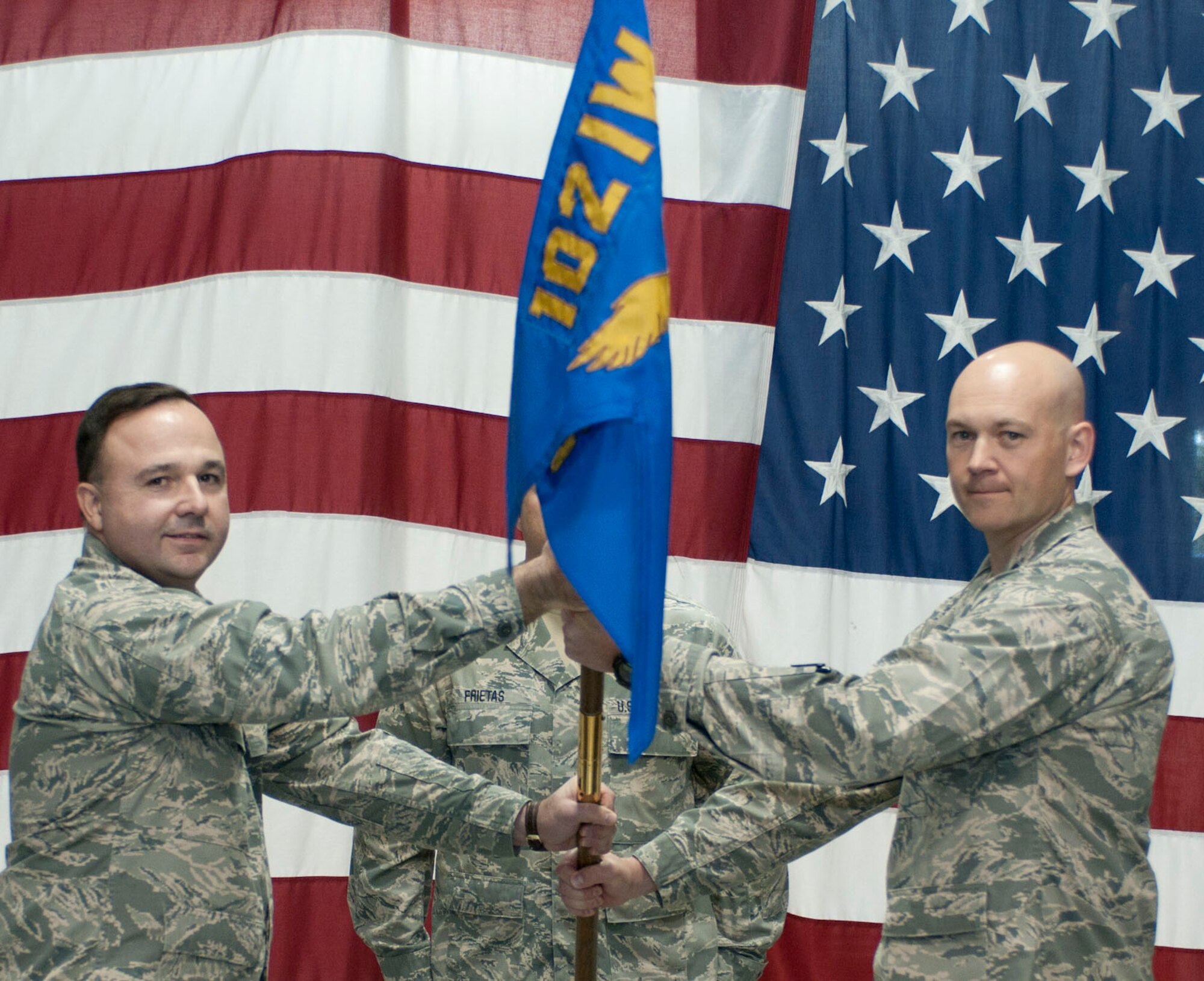 Lt. Col. Christopher Hamilton, 102nd Mission Support Group commander, passes the 102nd Security Forces Squadron flag to Capt. Christian Leighton during an assumption of command ceremony on Otis Air National Guard Base Dec. 2. Leighton assumed command of the 102nd Security Forces Squadron, which he was once a member of as an enlisted Airman. (Air National Guard photo by Senior Airman Patrick McKenna/Released)